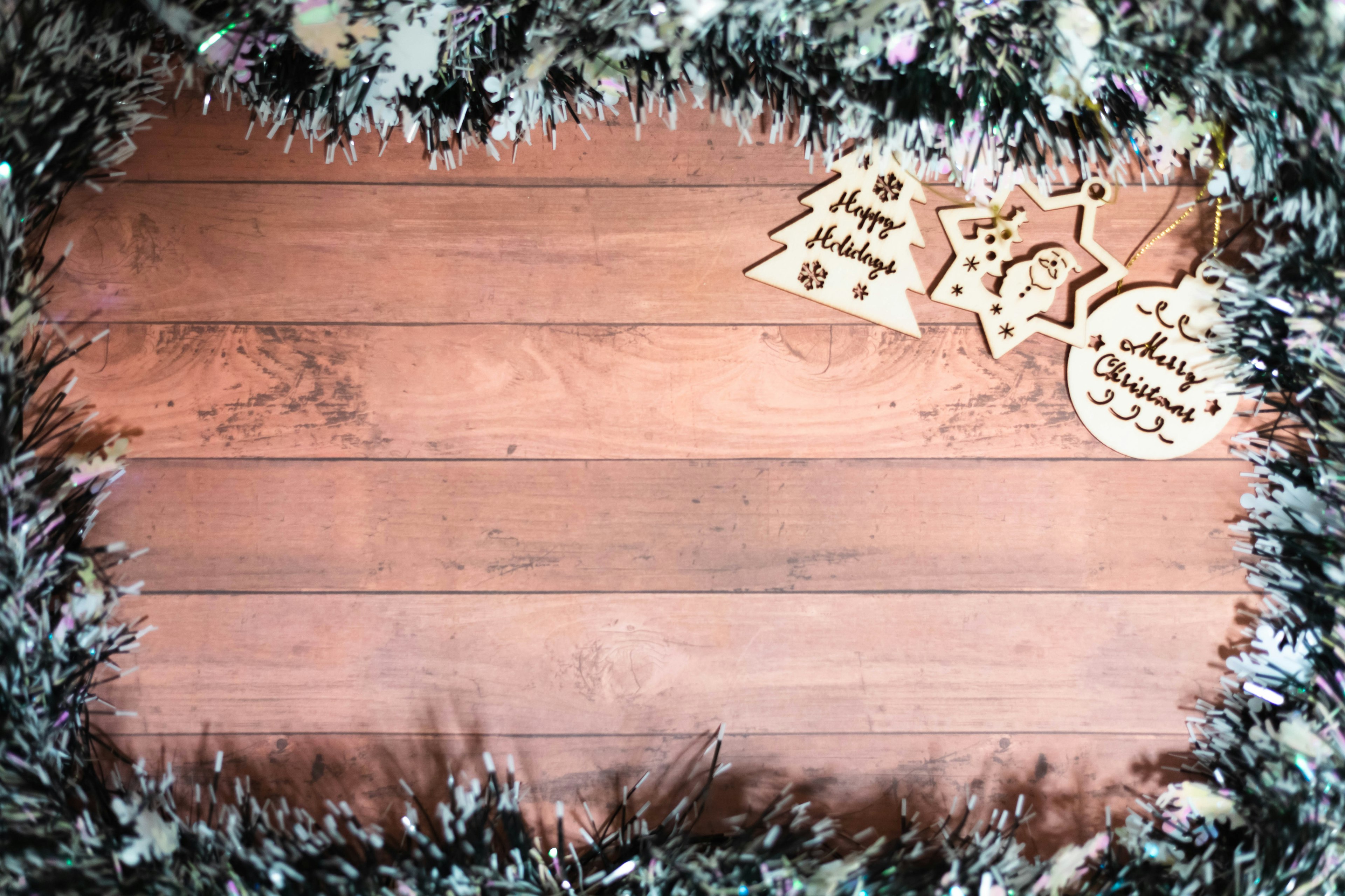 Adornos navideños en forma de árbol y estrella sobre un fondo de madera