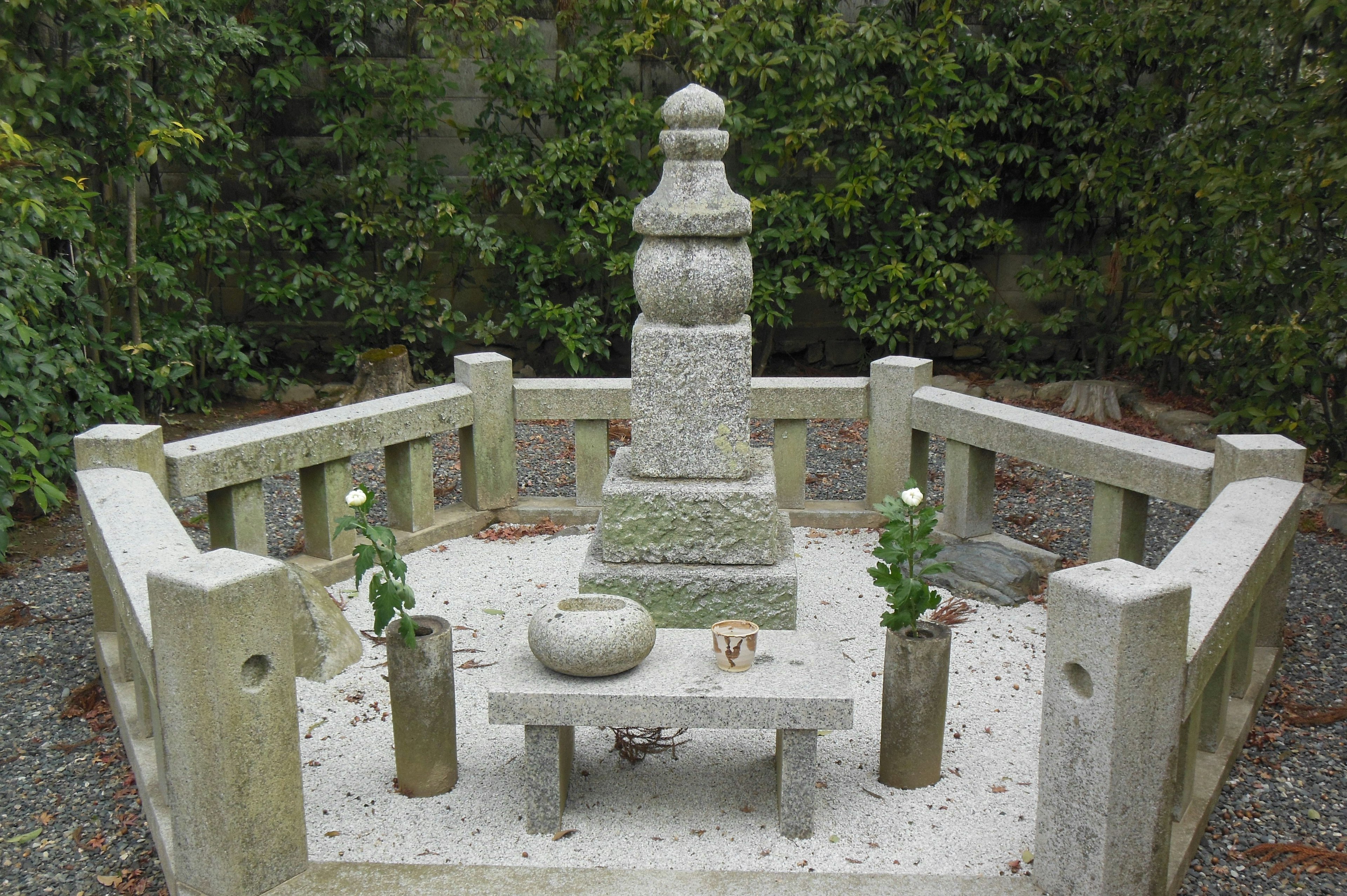 Quiet cemetery scene with a stone monument and surrounding enclosure