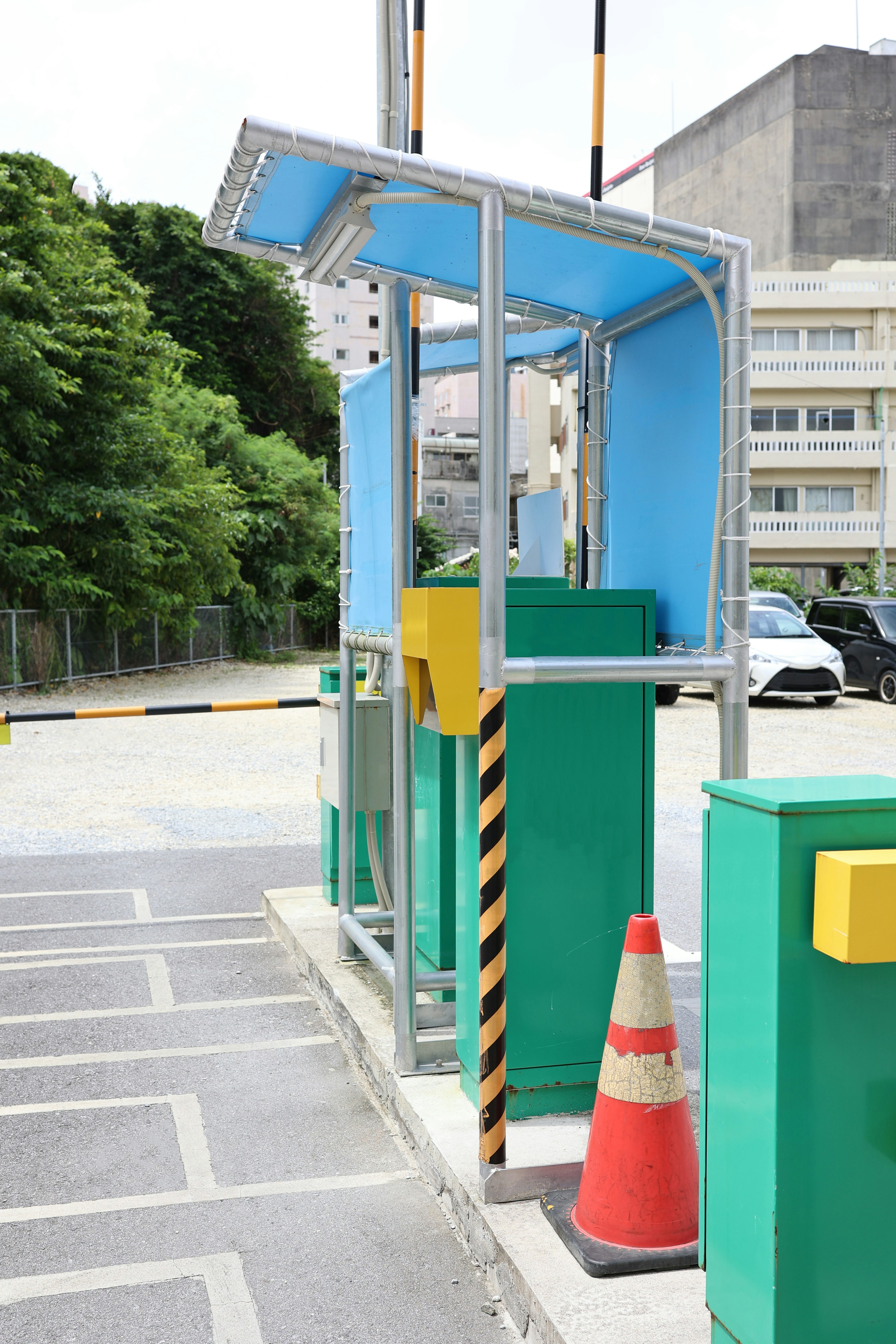 Bilik pembayaran parkir dengan atap biru dan kolom hijau