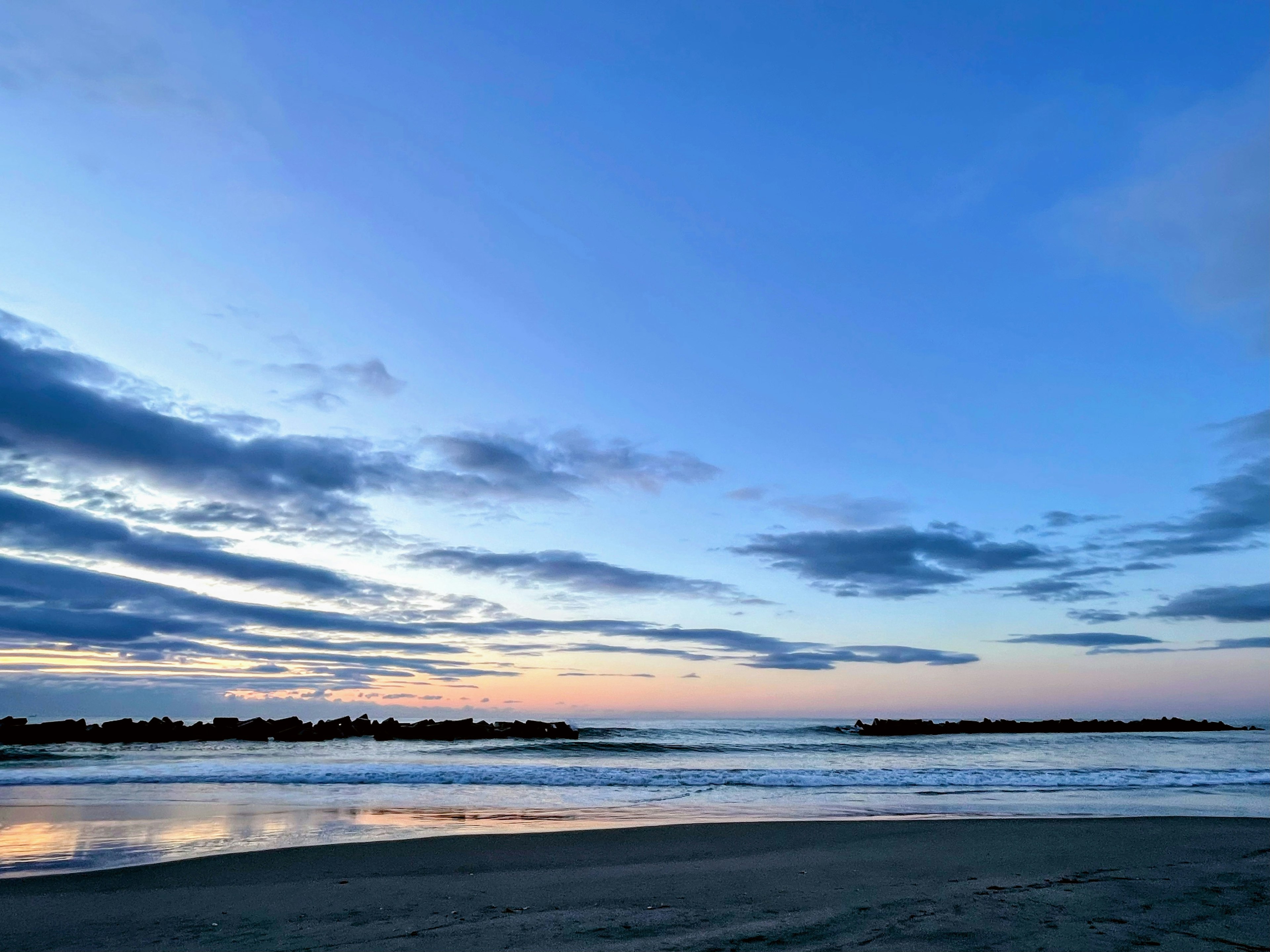 Plage magnifique au coucher du soleil avec mer calme et ciel coloré