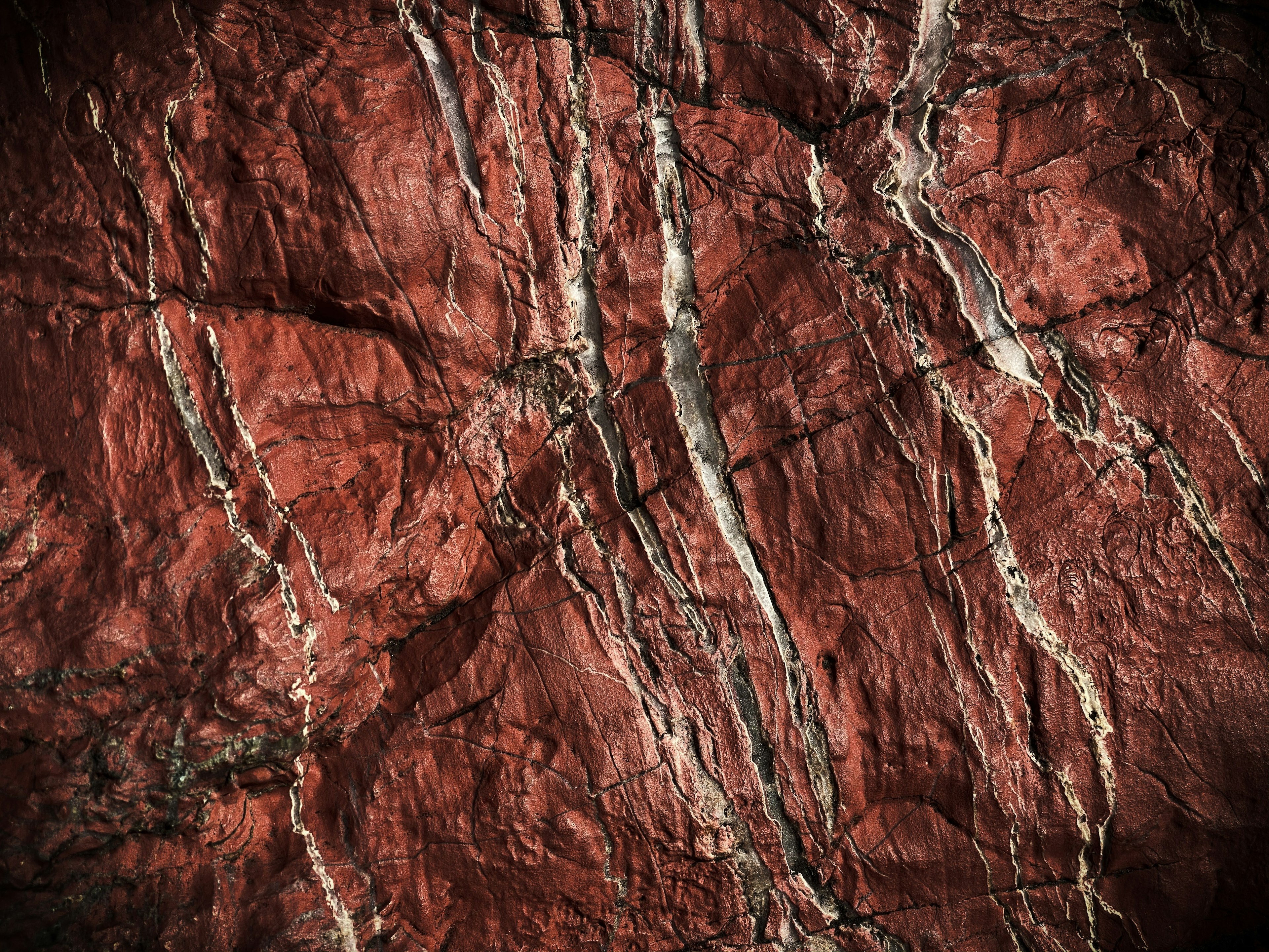 Surface de rocher rouge avec des veines blanches