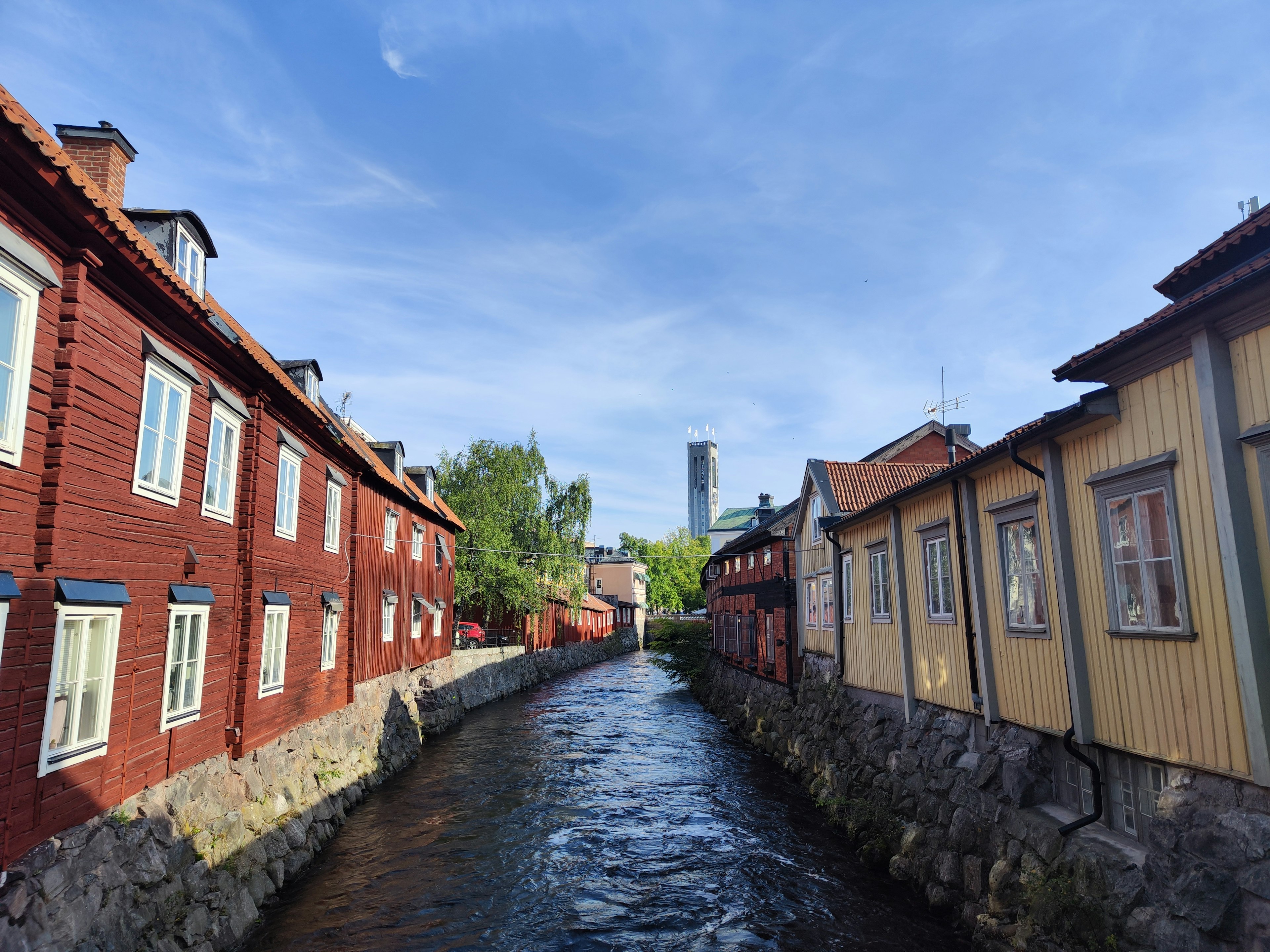 Vue pittoresque de maisons en bois rouges le long d'un cours d'eau calme