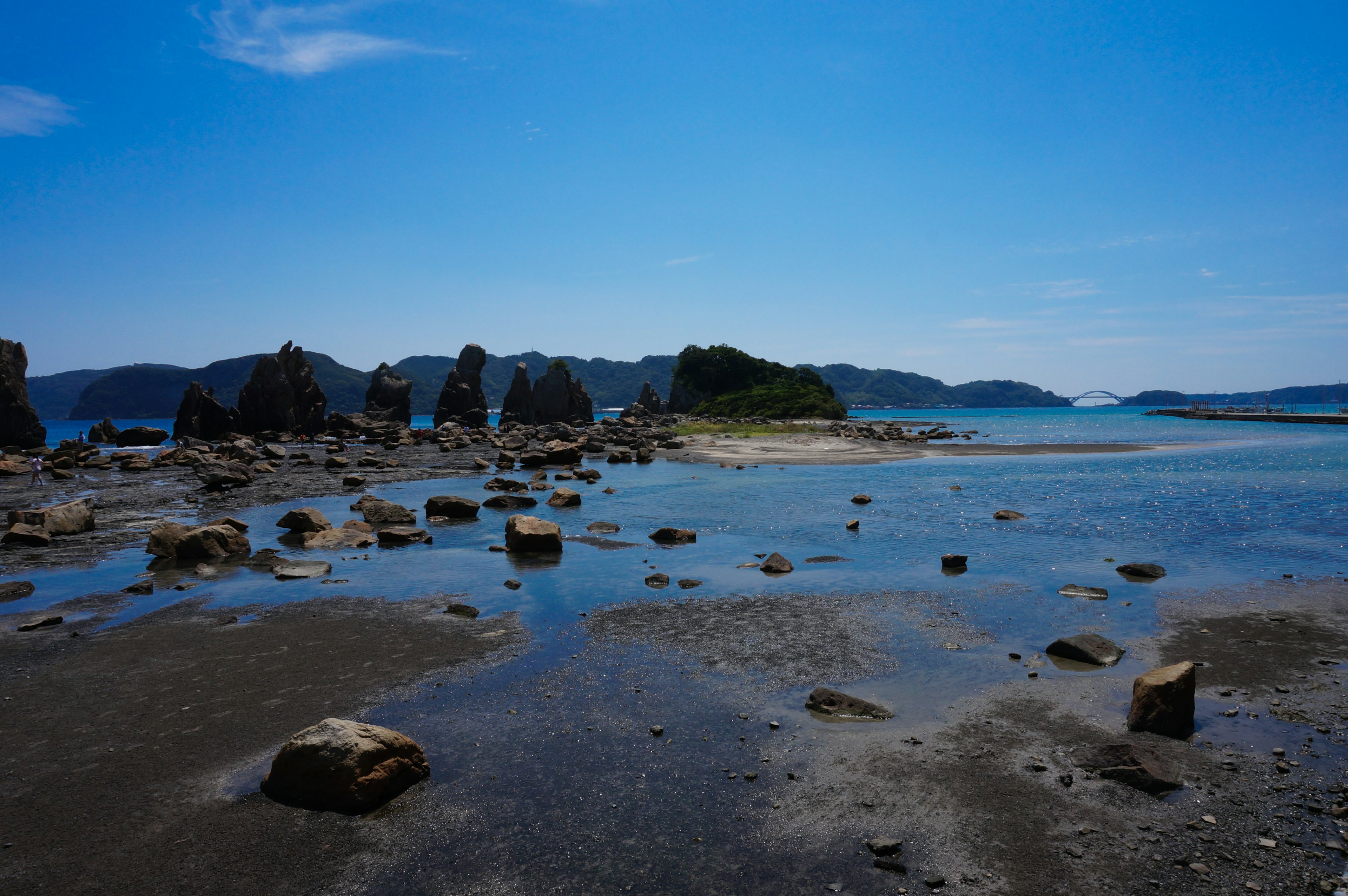 Pemandangan pantai dengan langit biru dan batu-batu tersebar