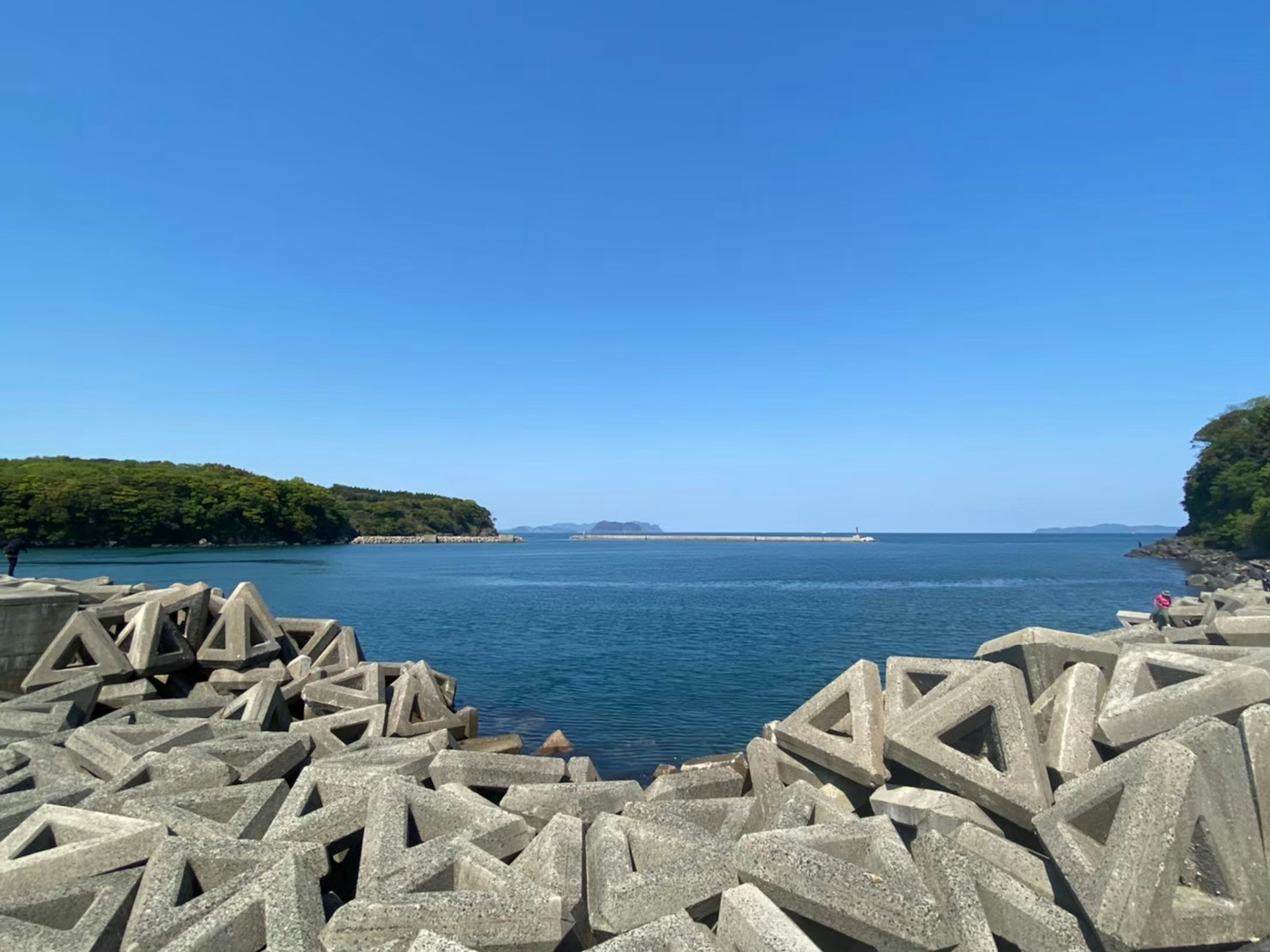 Vista escénica del mar azul y el rompeolas de concreto