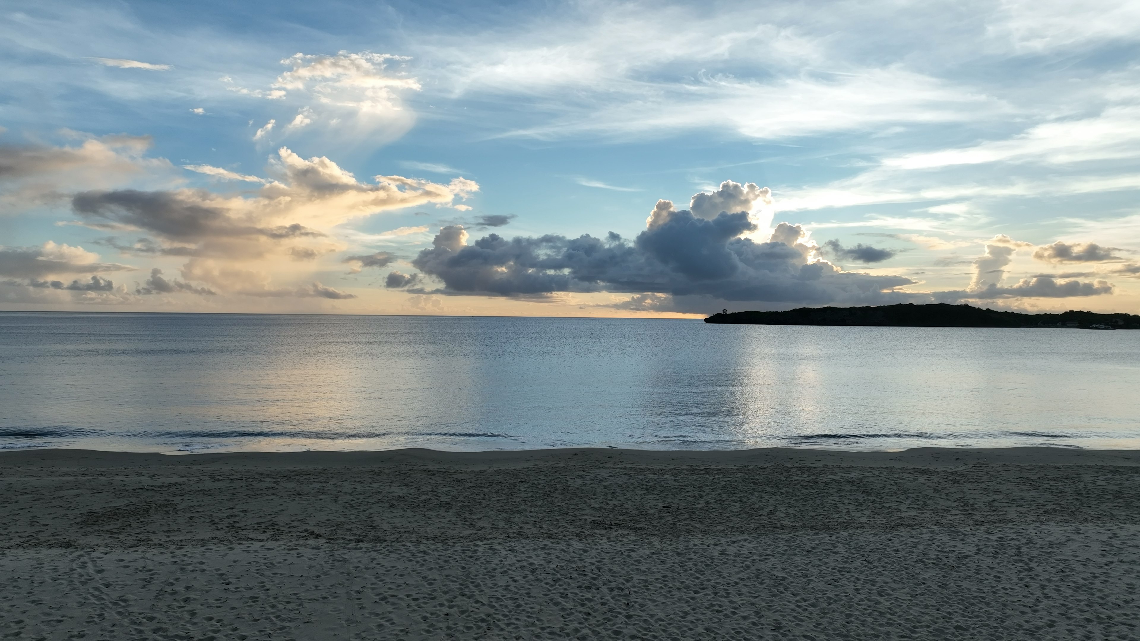 Escena de playa tranquila con mar calmado y hermosas nubes