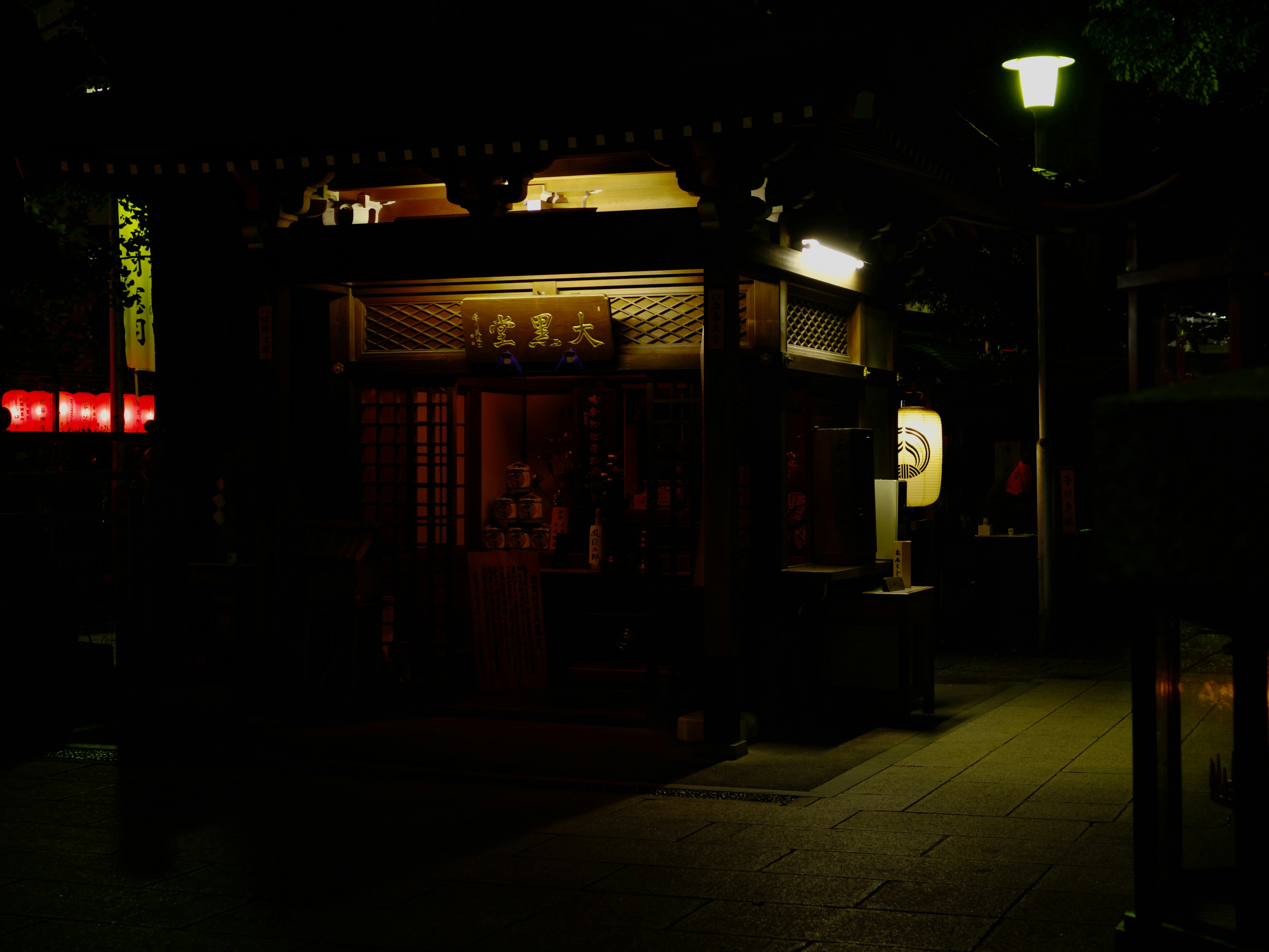 夜间照亮的小神社建筑和周围的灯光