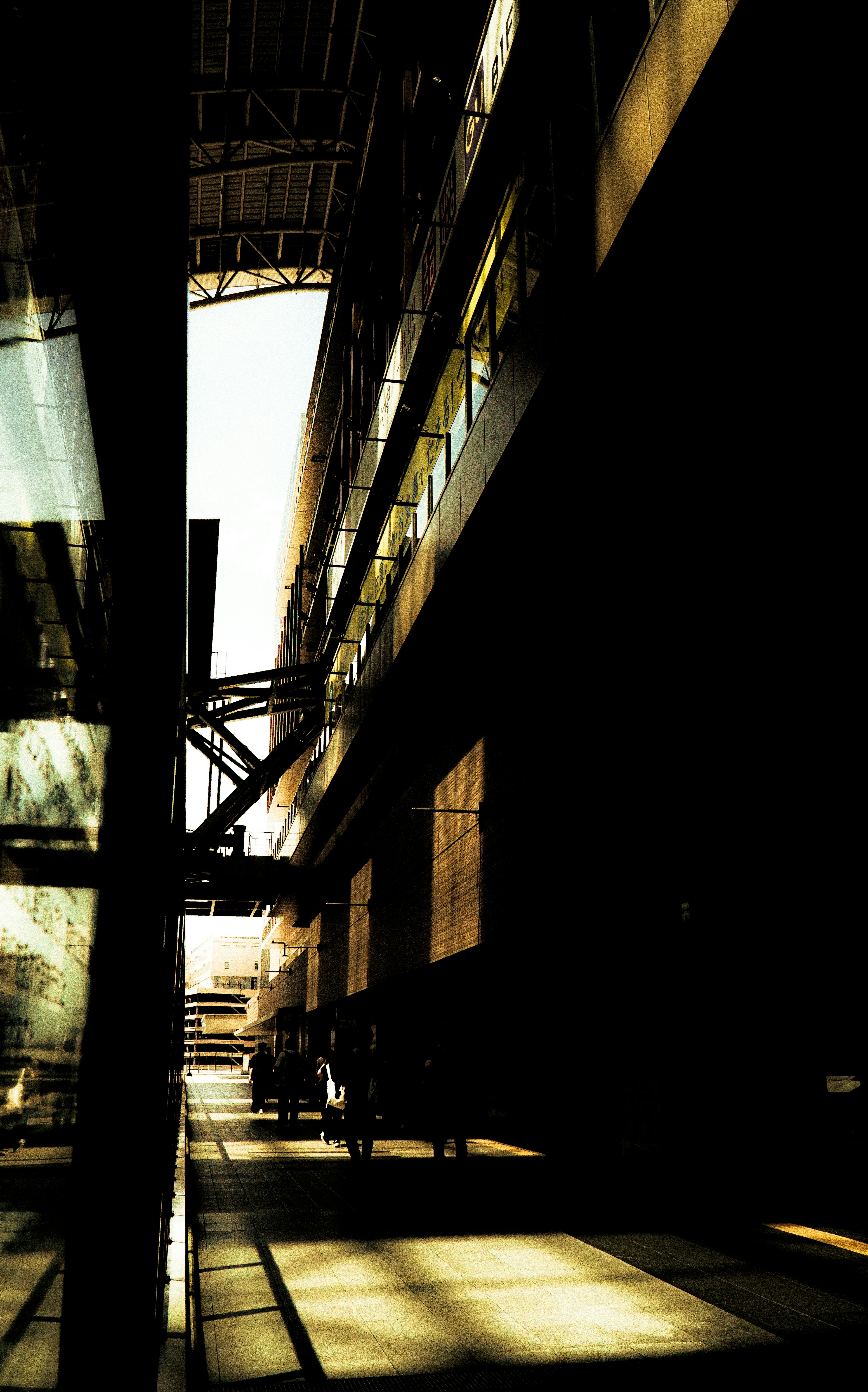 Silhouettes of people walking towards a courtyard in modern architecture