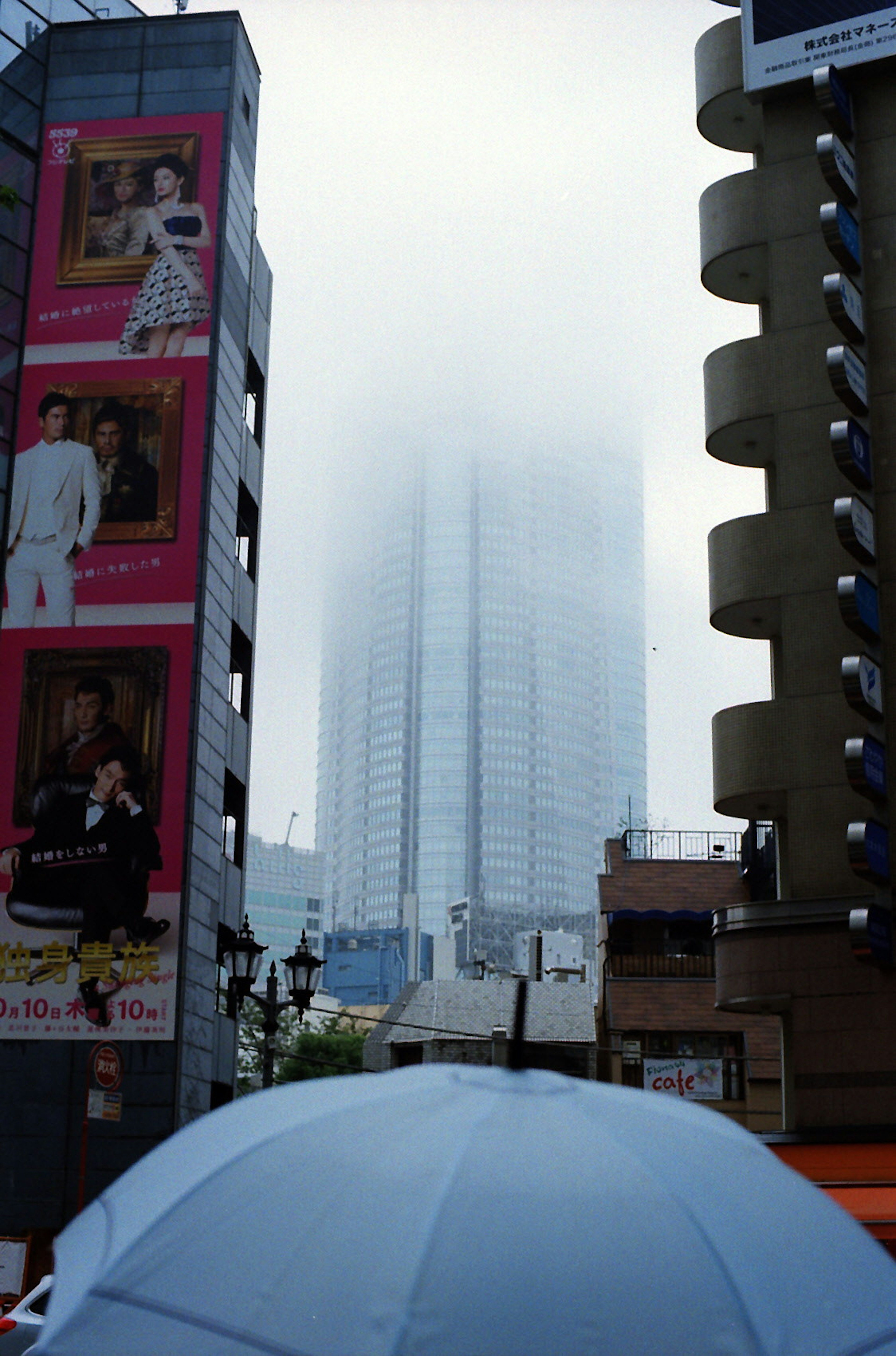 Cityscape featuring a misty skyscraper and an umbrella