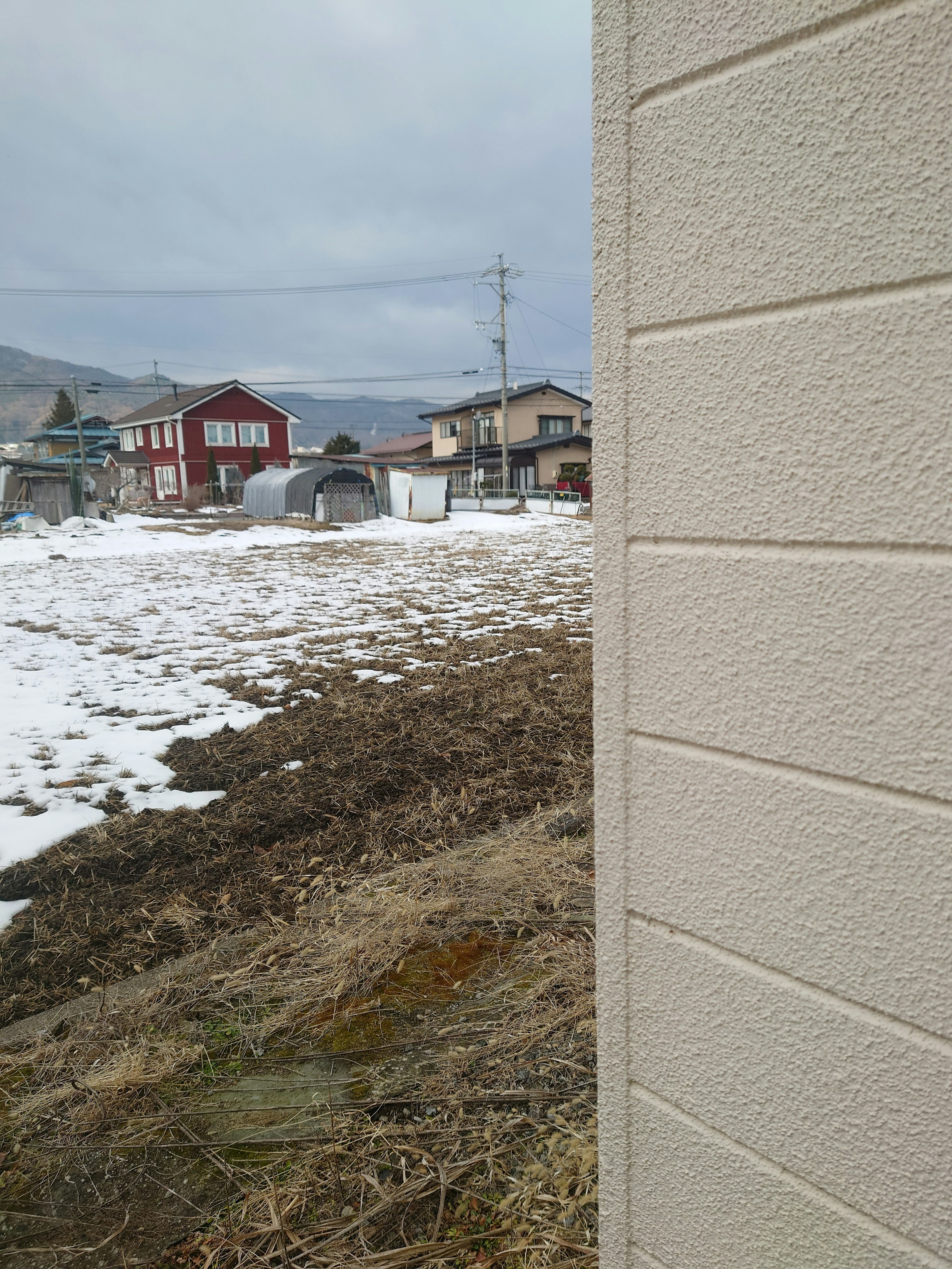 Paesaggio rurale con neve e case sullo sfondo