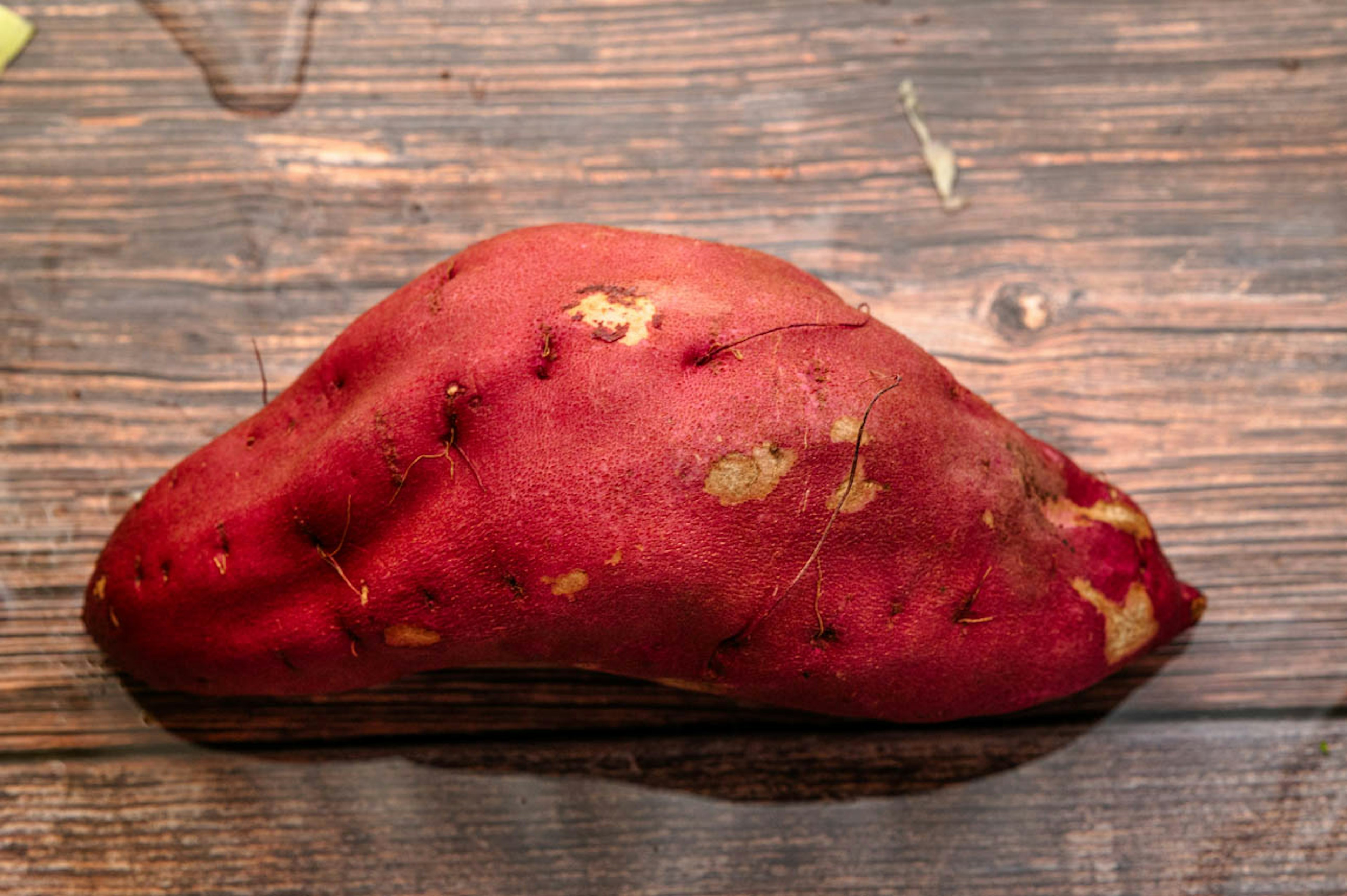 A red sweet potato placed on a wooden table