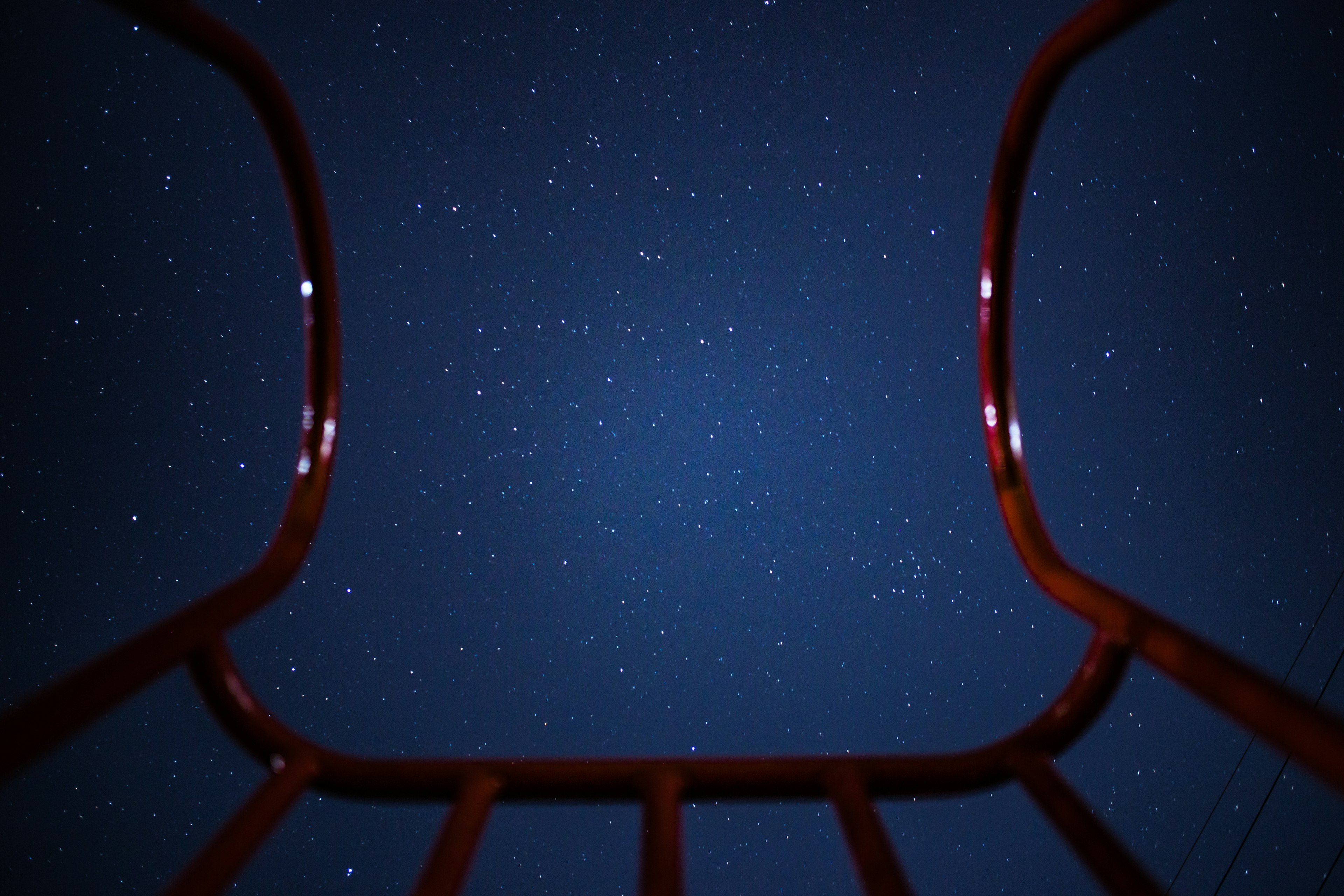 Cielo estrellado visto a través de un marco de parque infantil rojo