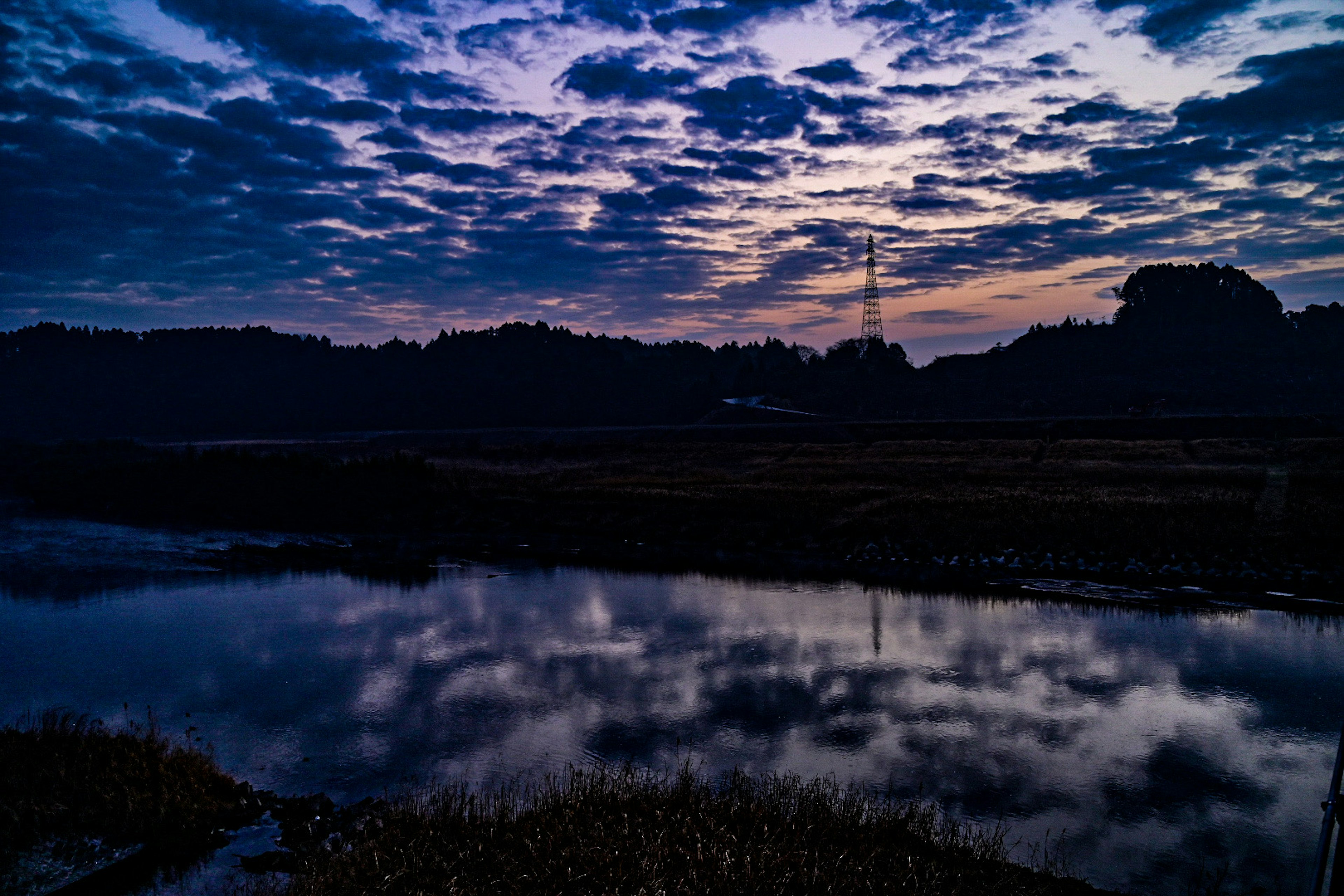 夕暮れ時の川と雲の美しい反射が見える風景