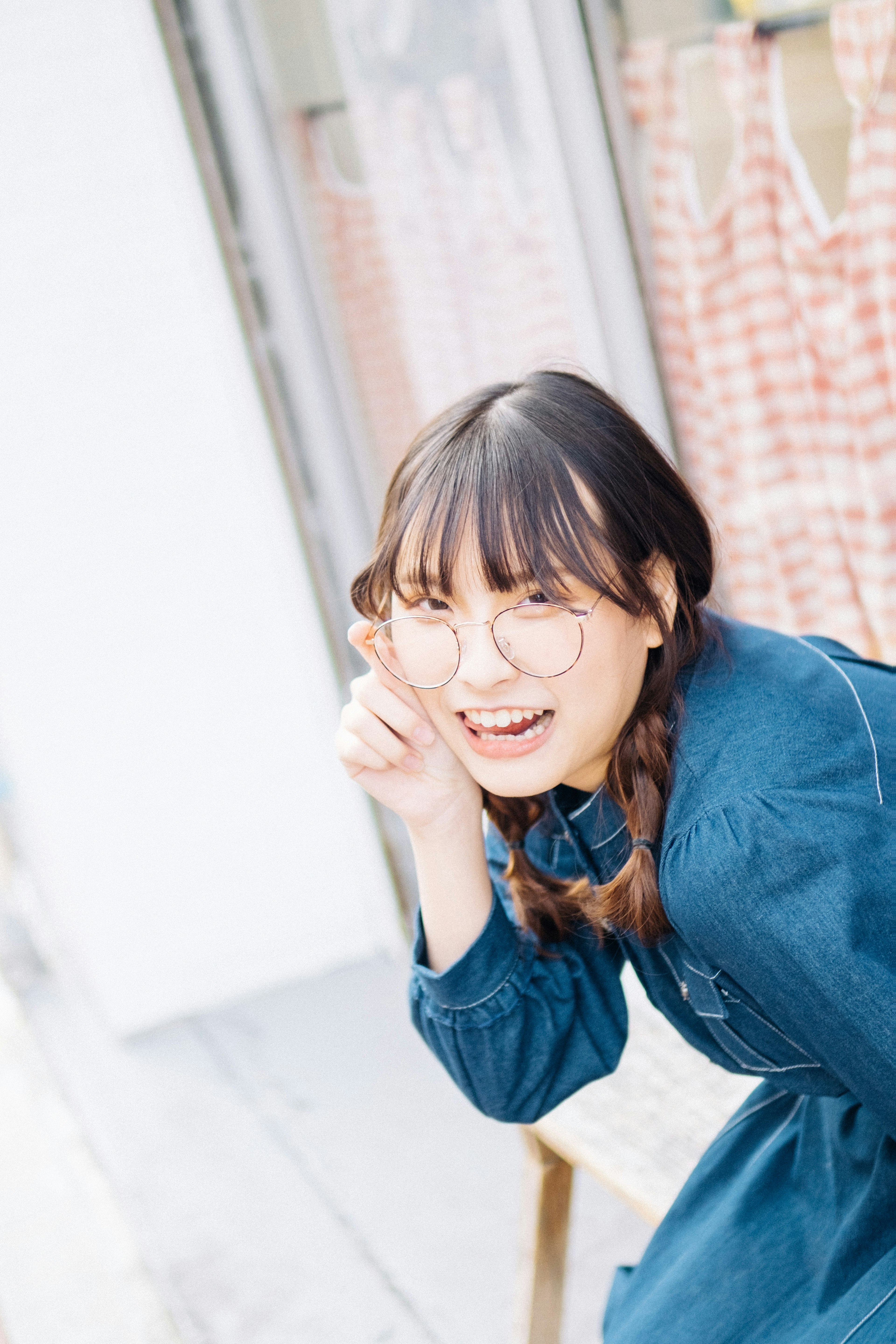 A smiling woman wearing glasses making a playful pose