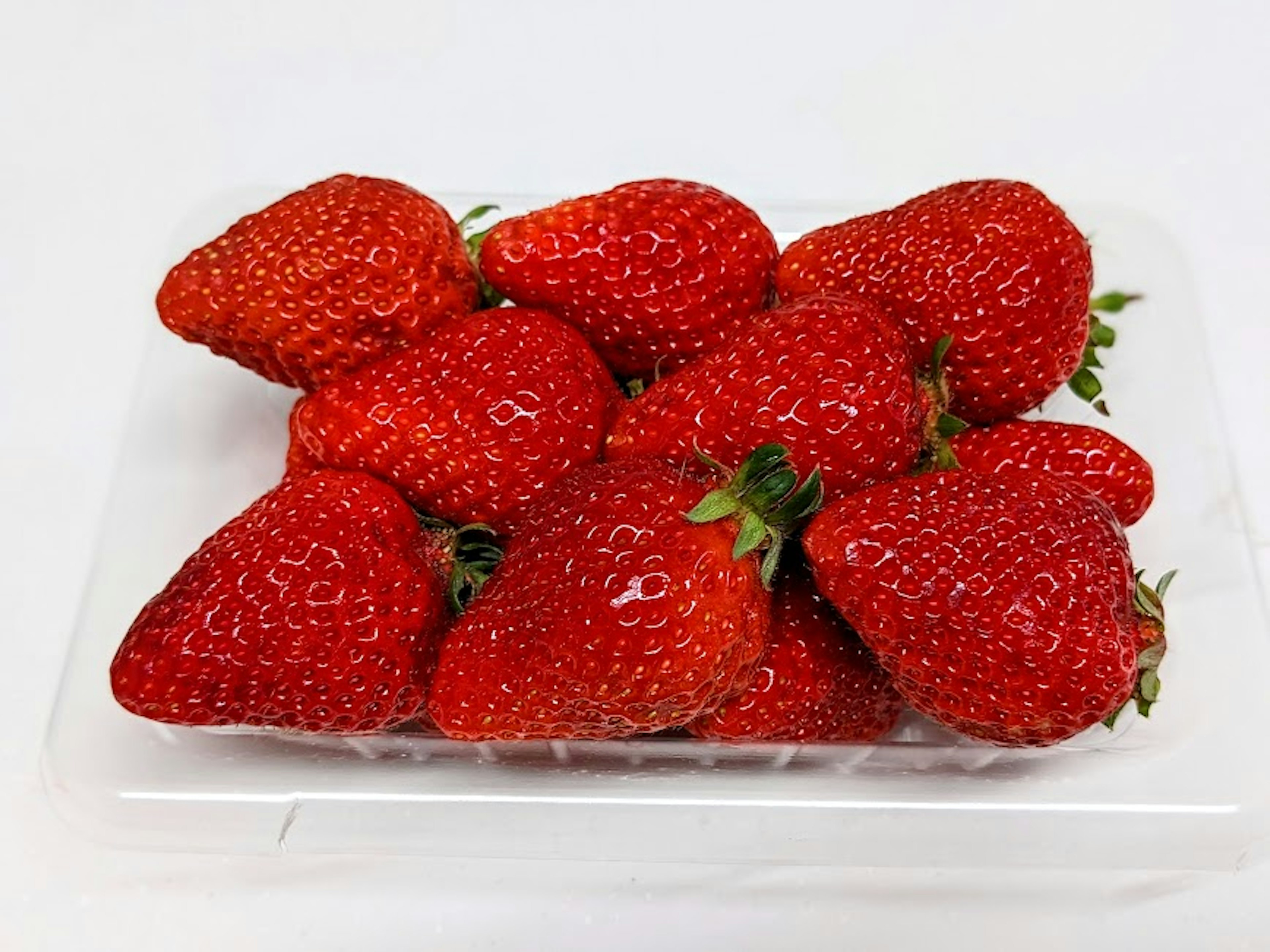 Fresh strawberries arranged in a plastic tray