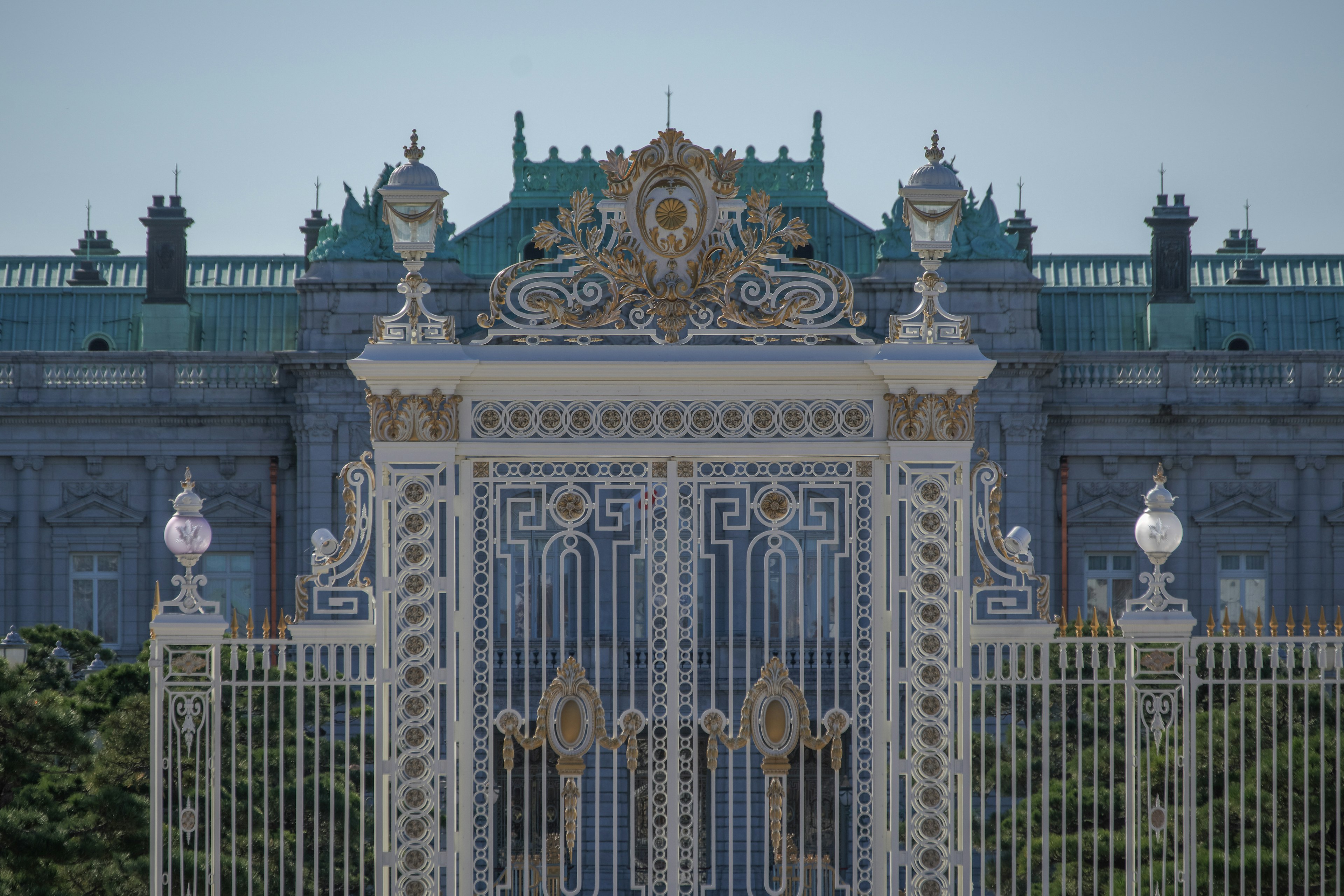 Puerta lujosa con decoraciones doradas y un gran edificio al fondo