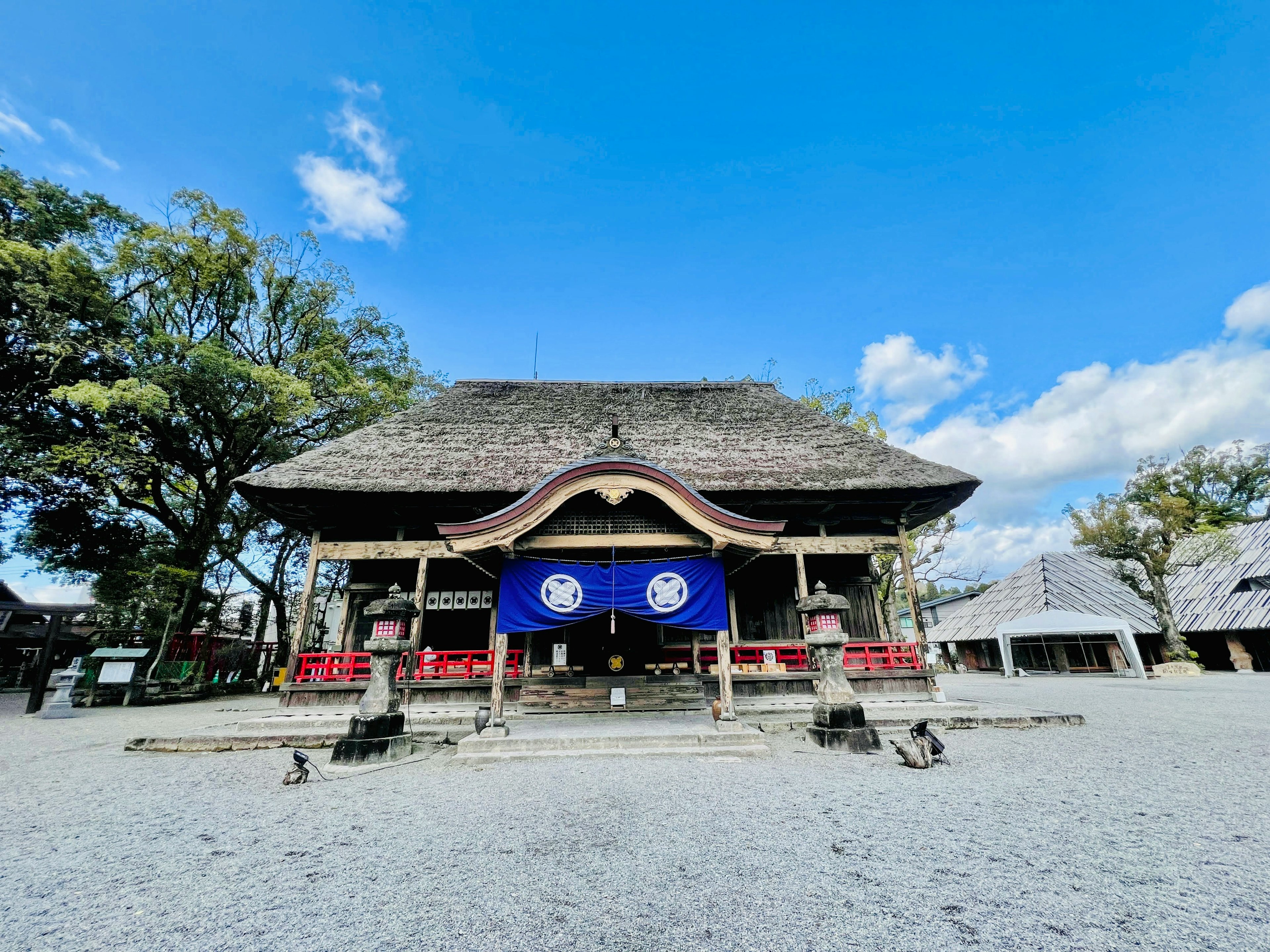 Traditionelles japanisches Schrein unter blauem Himmel und umgebender Natur