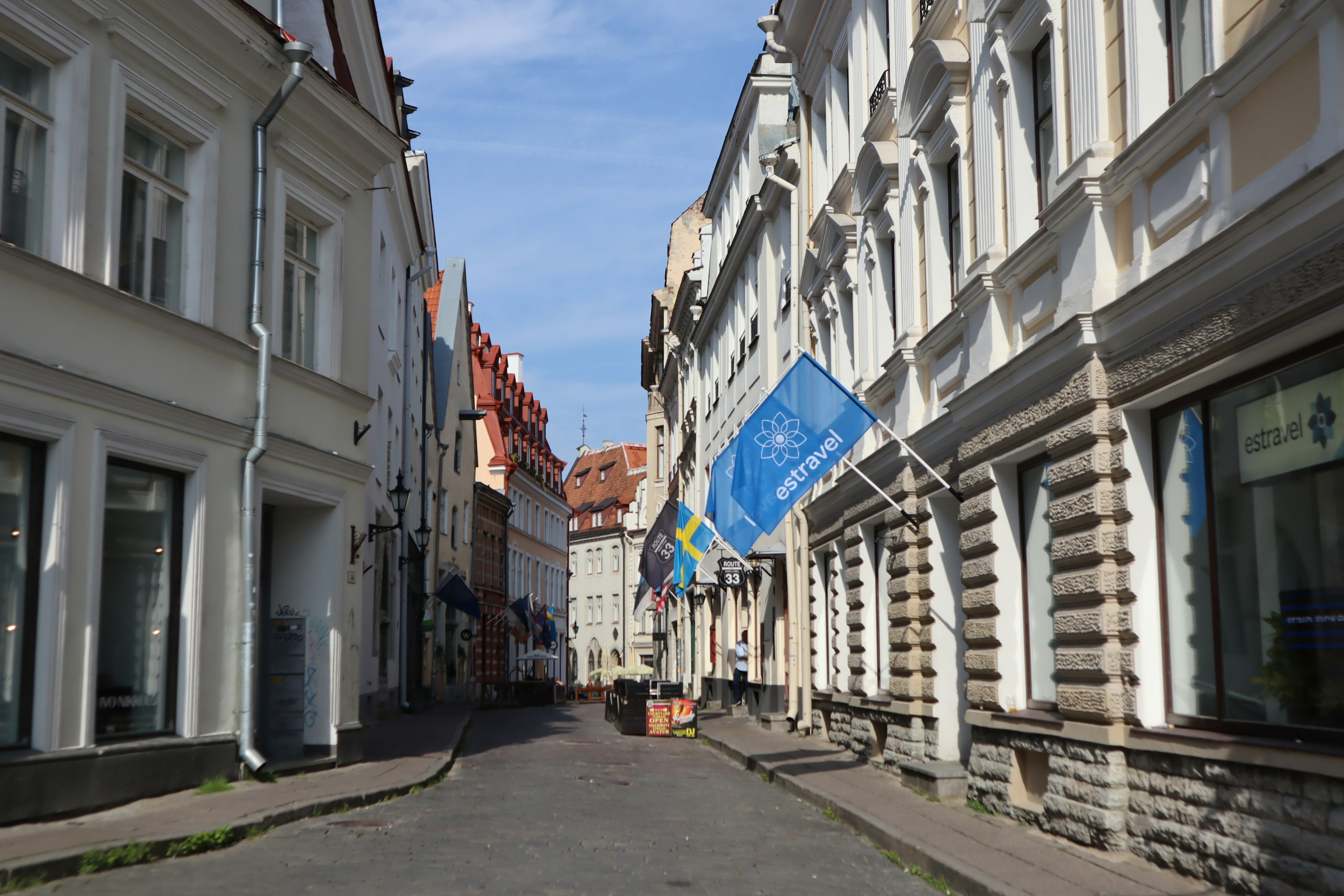 Quiet street with white buildings and blue flags