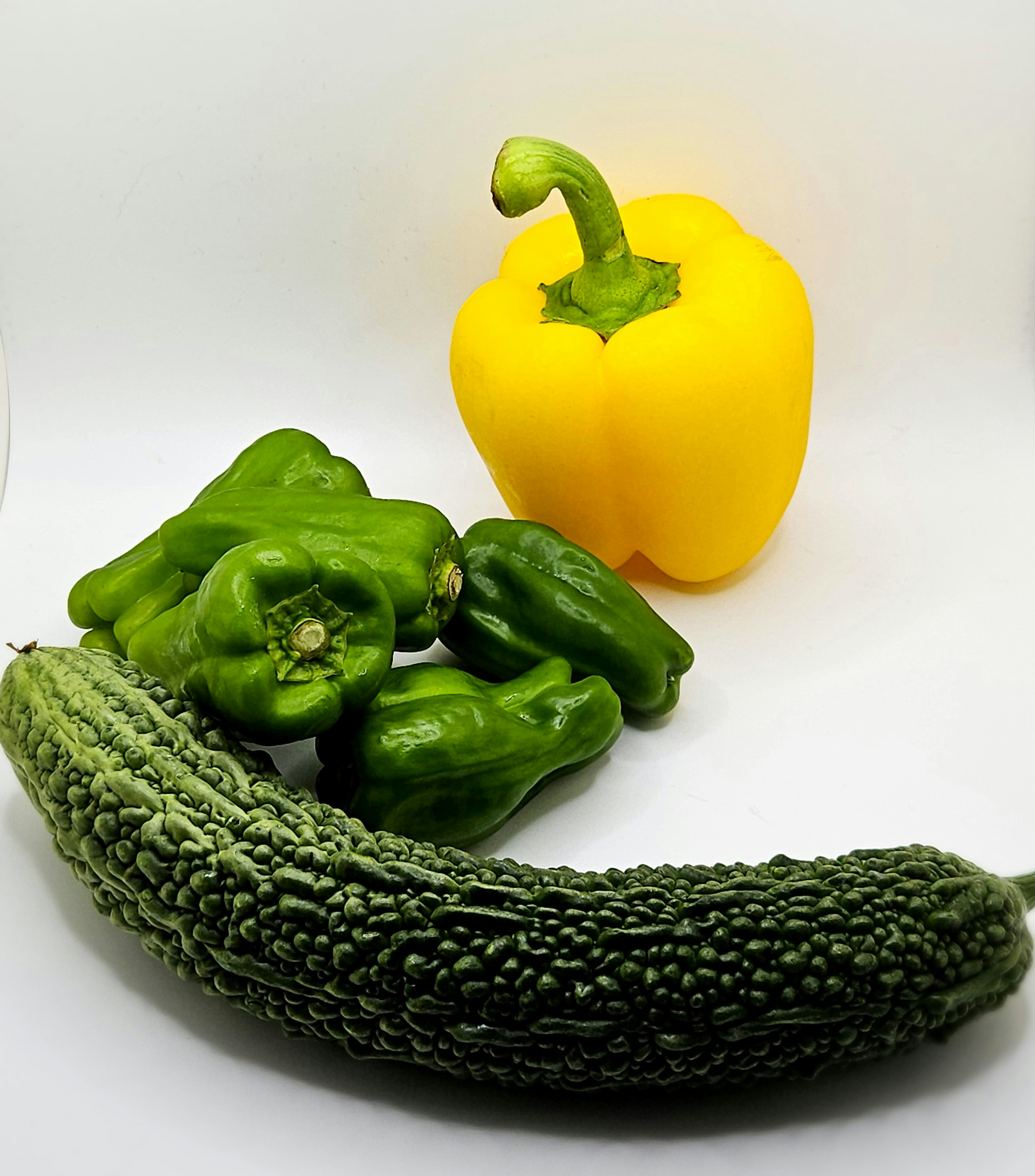 Colorful vegetables arranged in a photo yellow bell pepper green bell peppers bitter melon