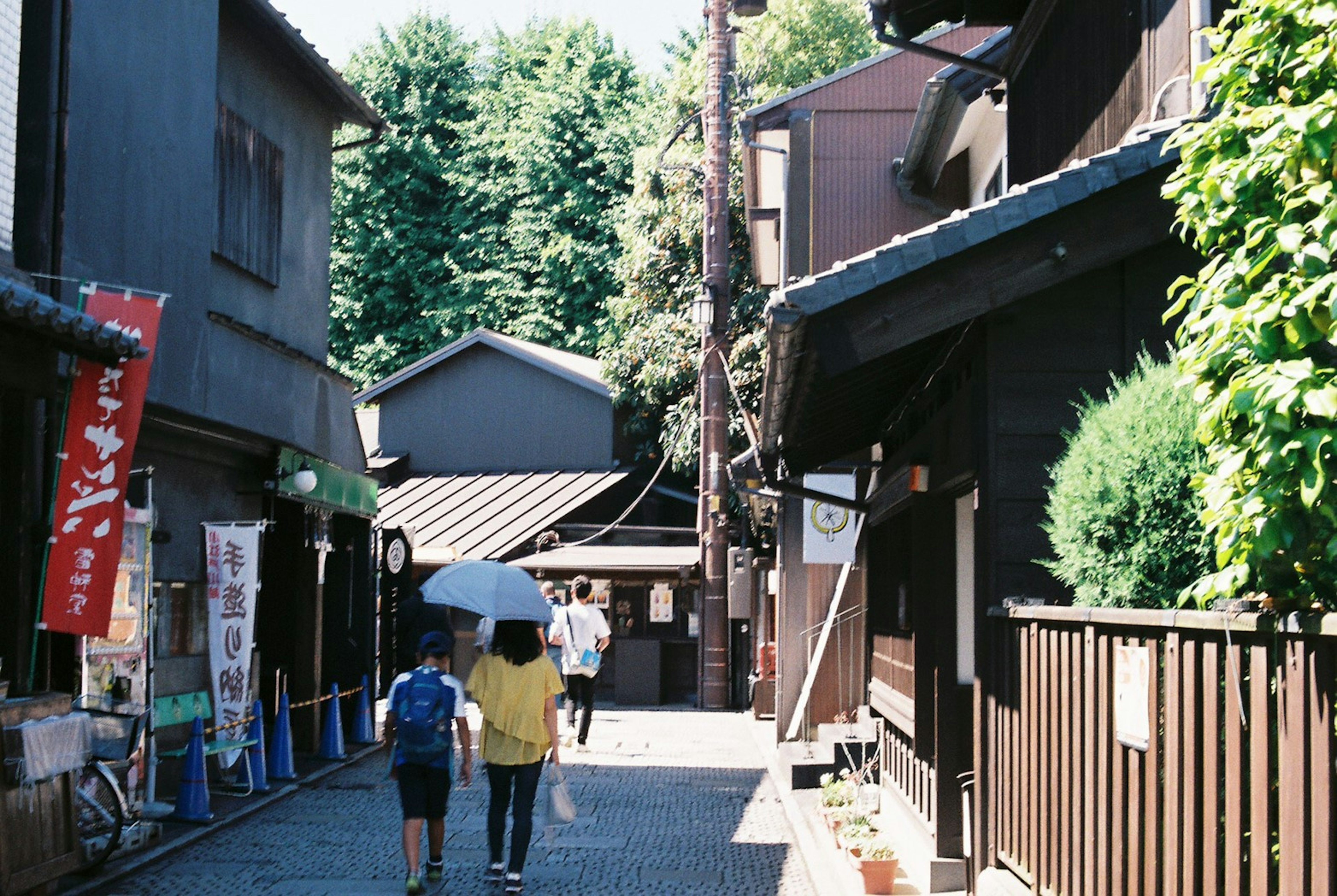 静かな街並みを散策する二人の人物と古い日本の建物