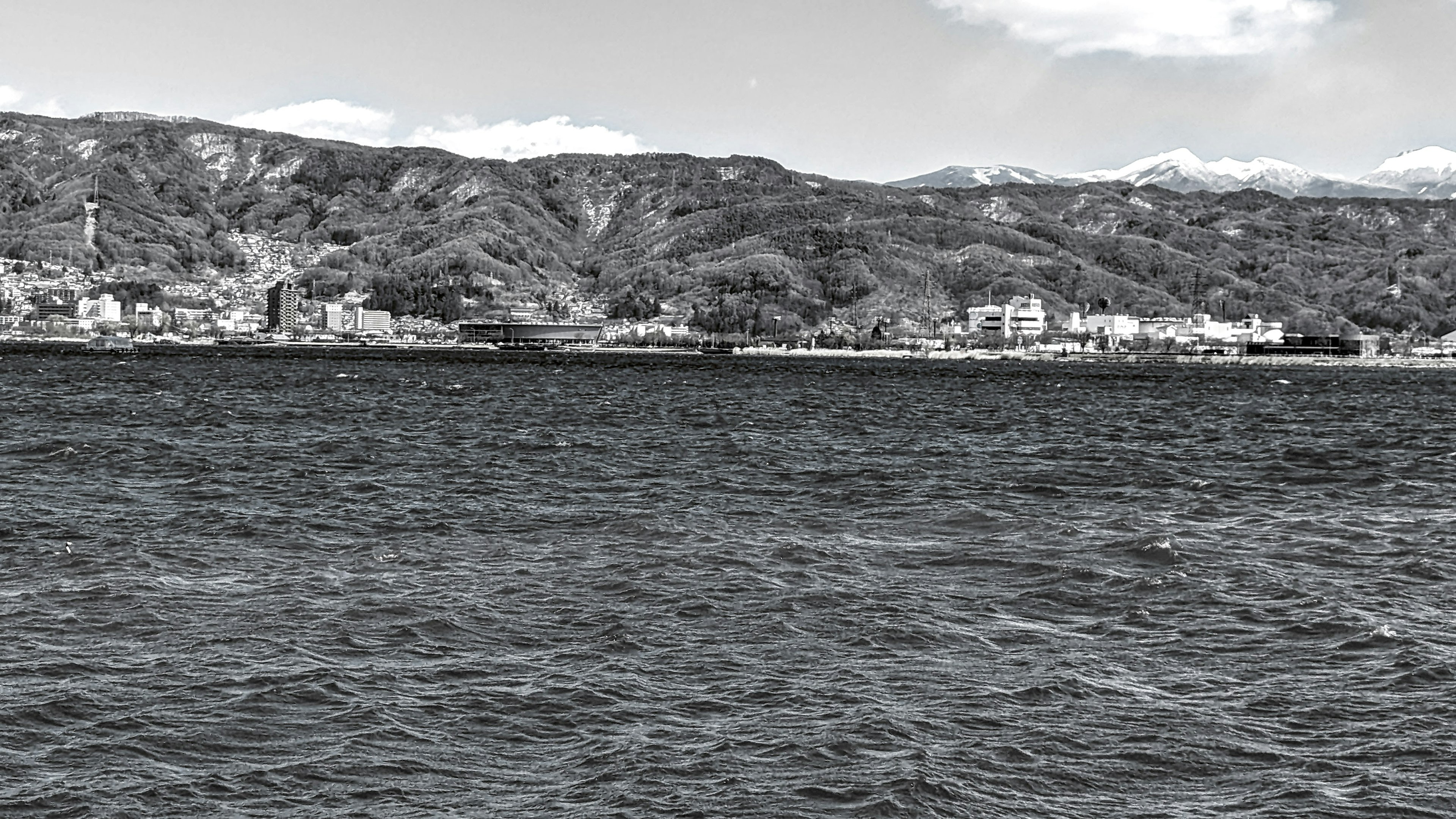 Schwarz-Weiß-Foto einer Küstenlandschaft mit Bergen