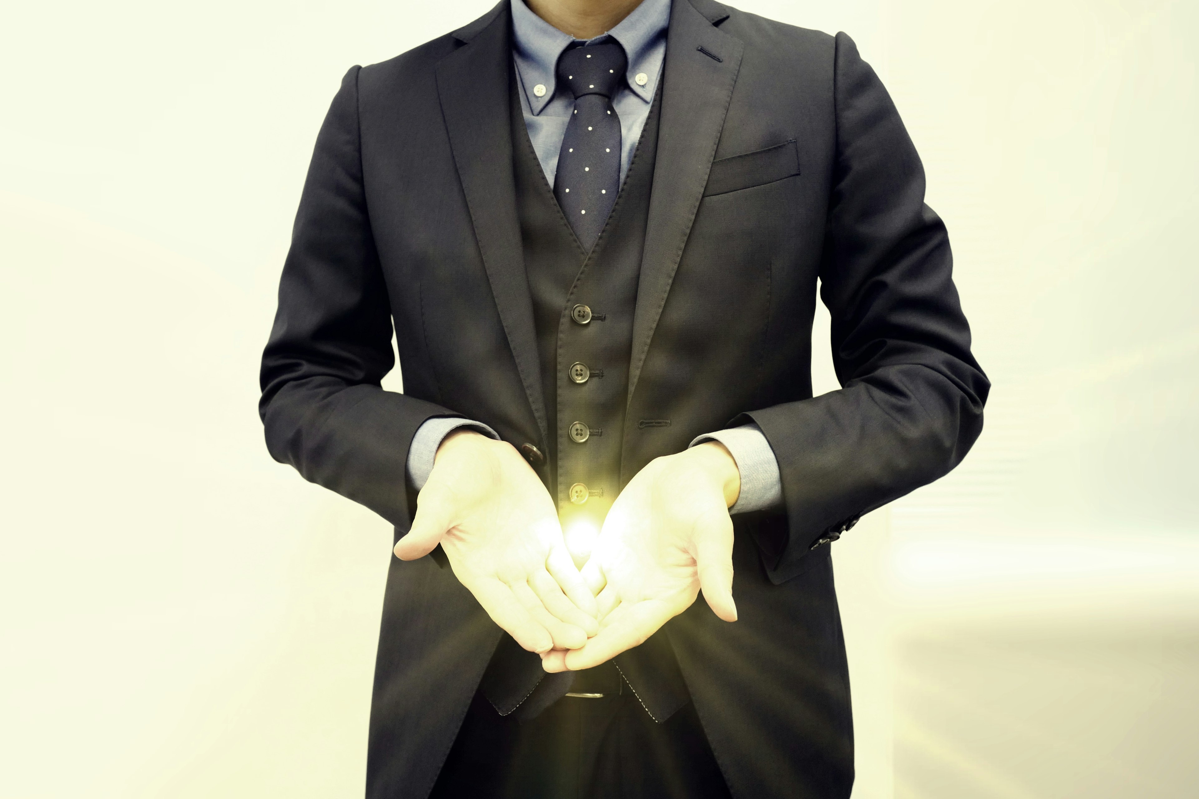 A man in a suit holding light in his hands