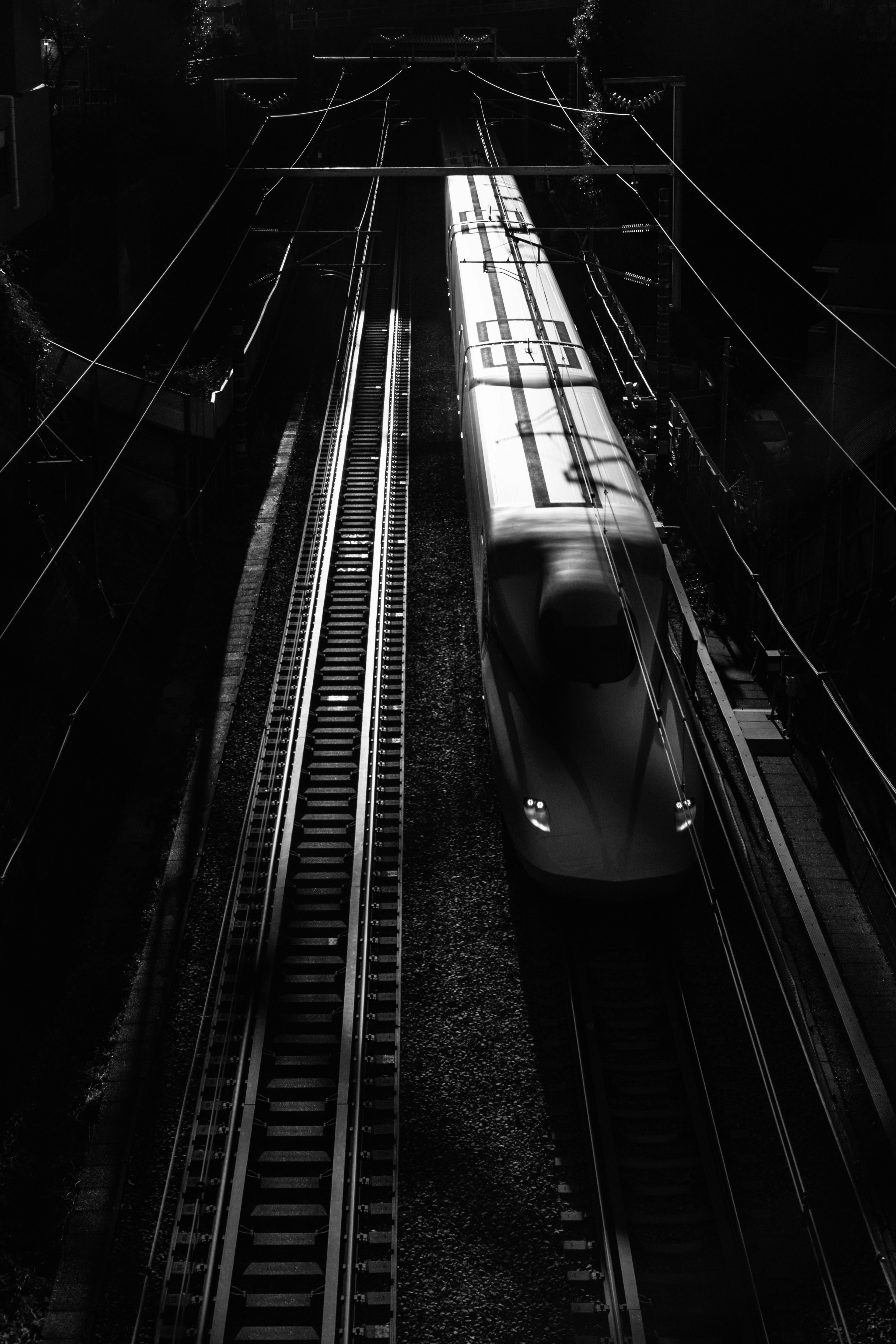 Silhouette d'un train à grande vitesse sur des rails en noir et blanc