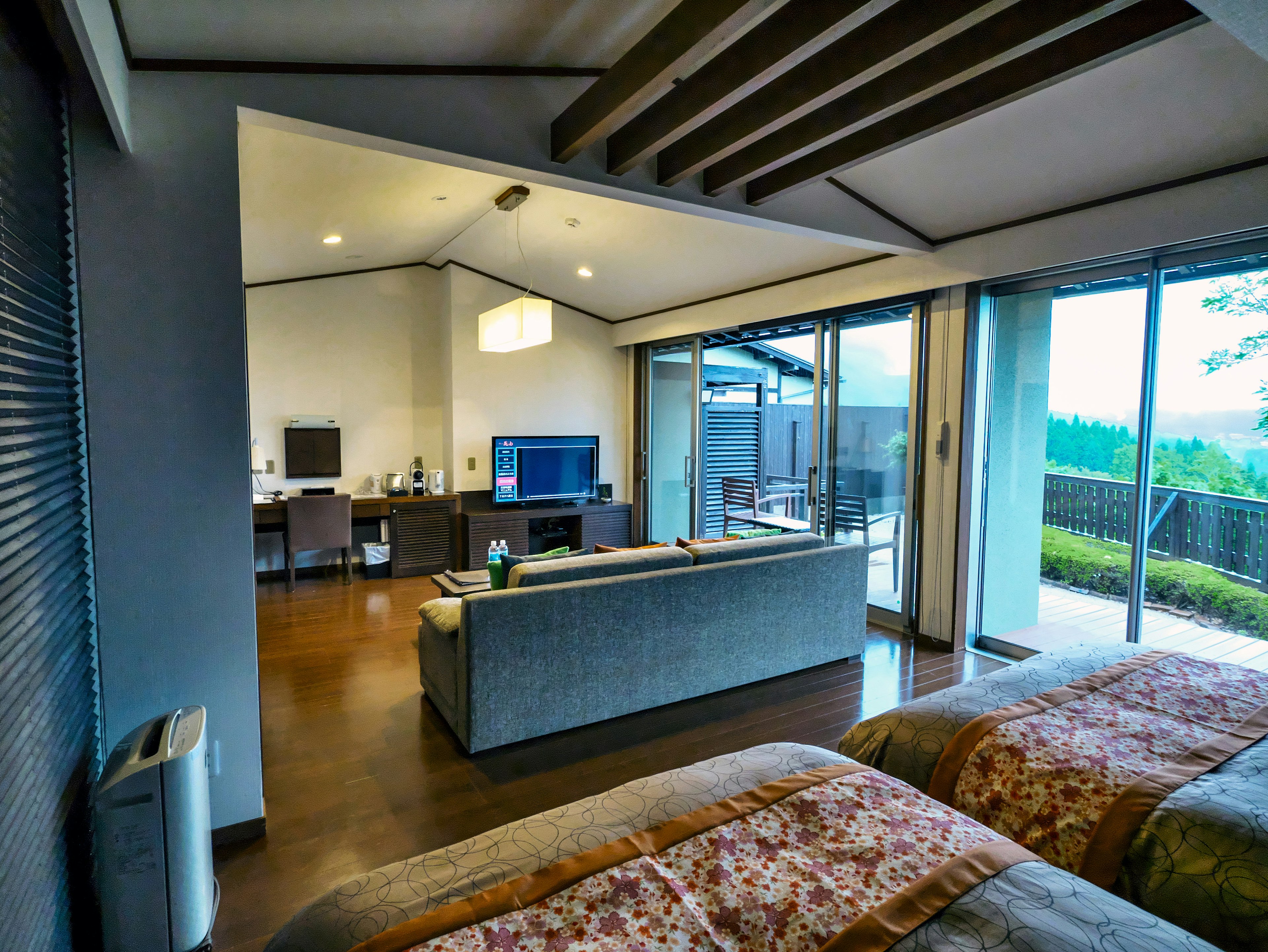 Interior de habitación moderna con dos camas, espacio de estar y hermosa vista a través de las ventanas