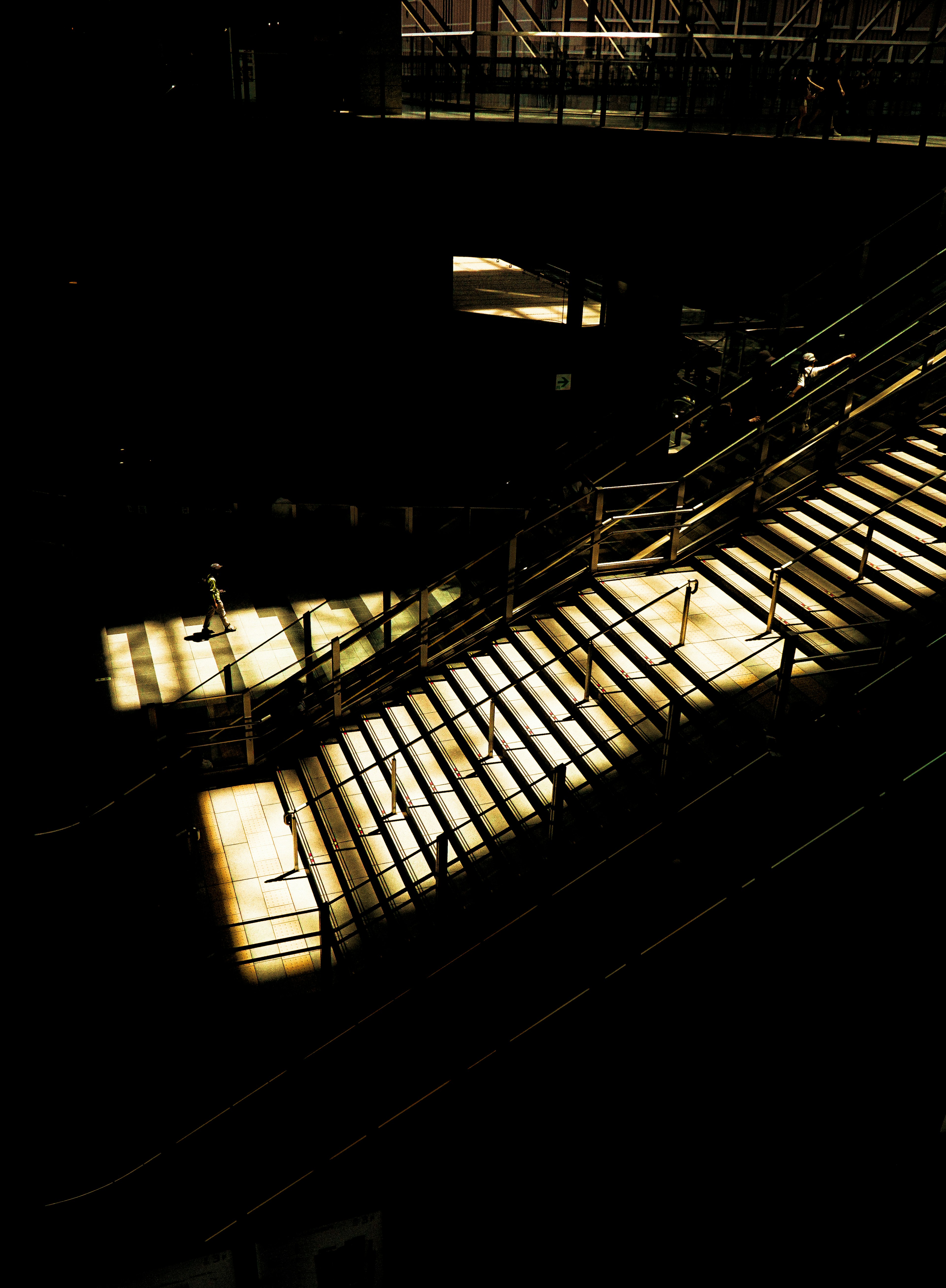 Escalier éclairé par une lumière dramatique et des ombres dans un cadre sombre