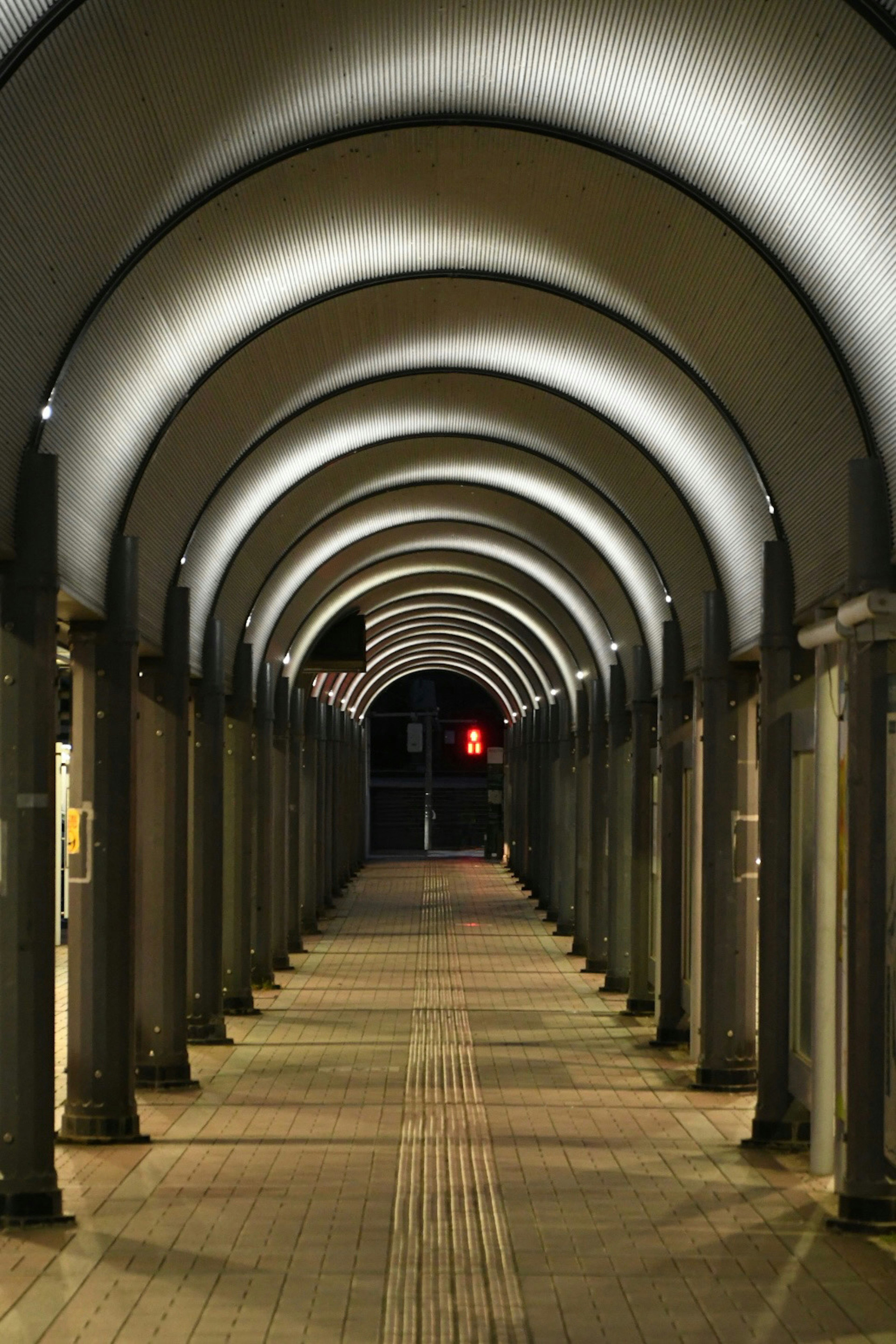 A well-lit archway corridor at night