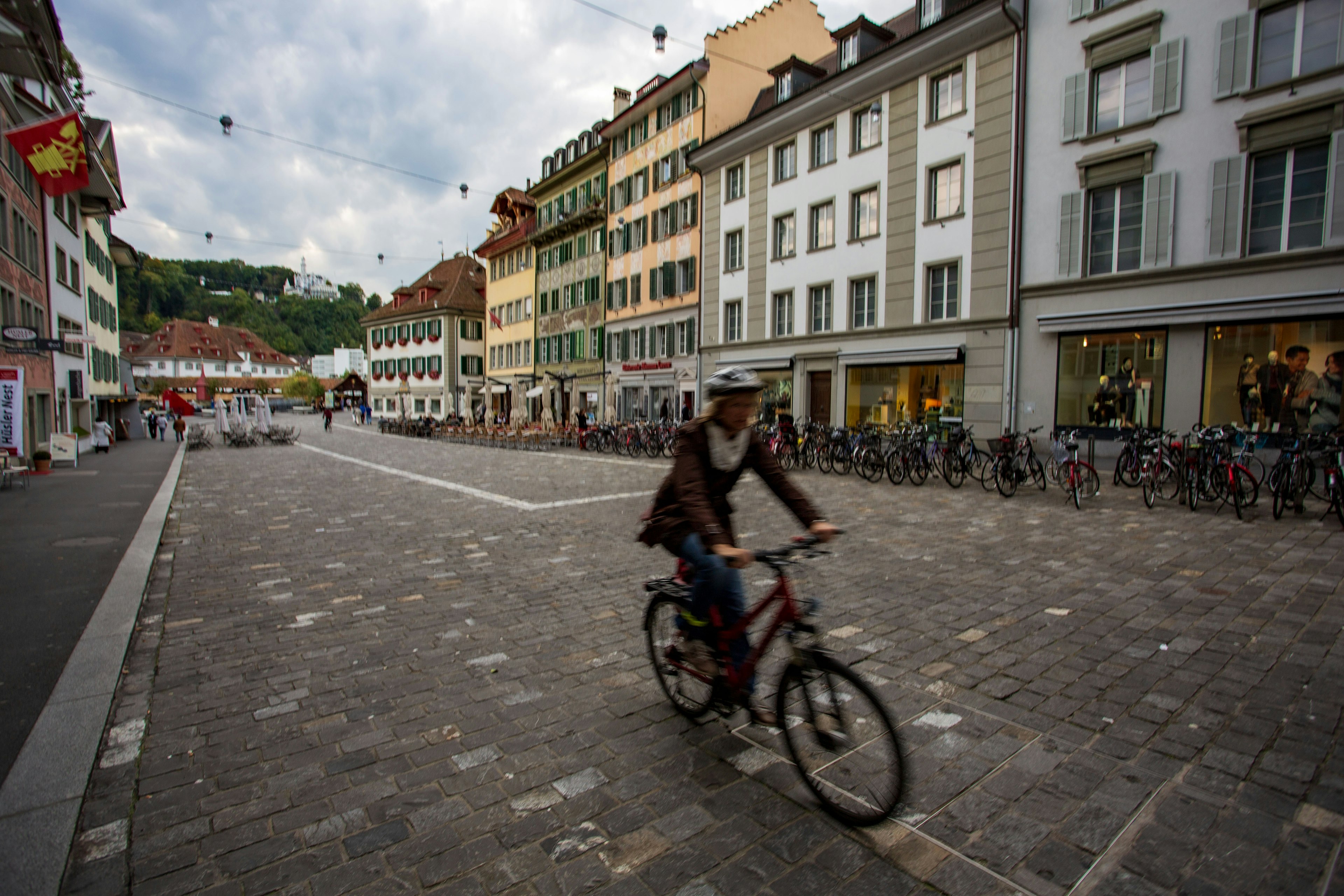 A cyclist riding on a cobblestone street in Lucerne