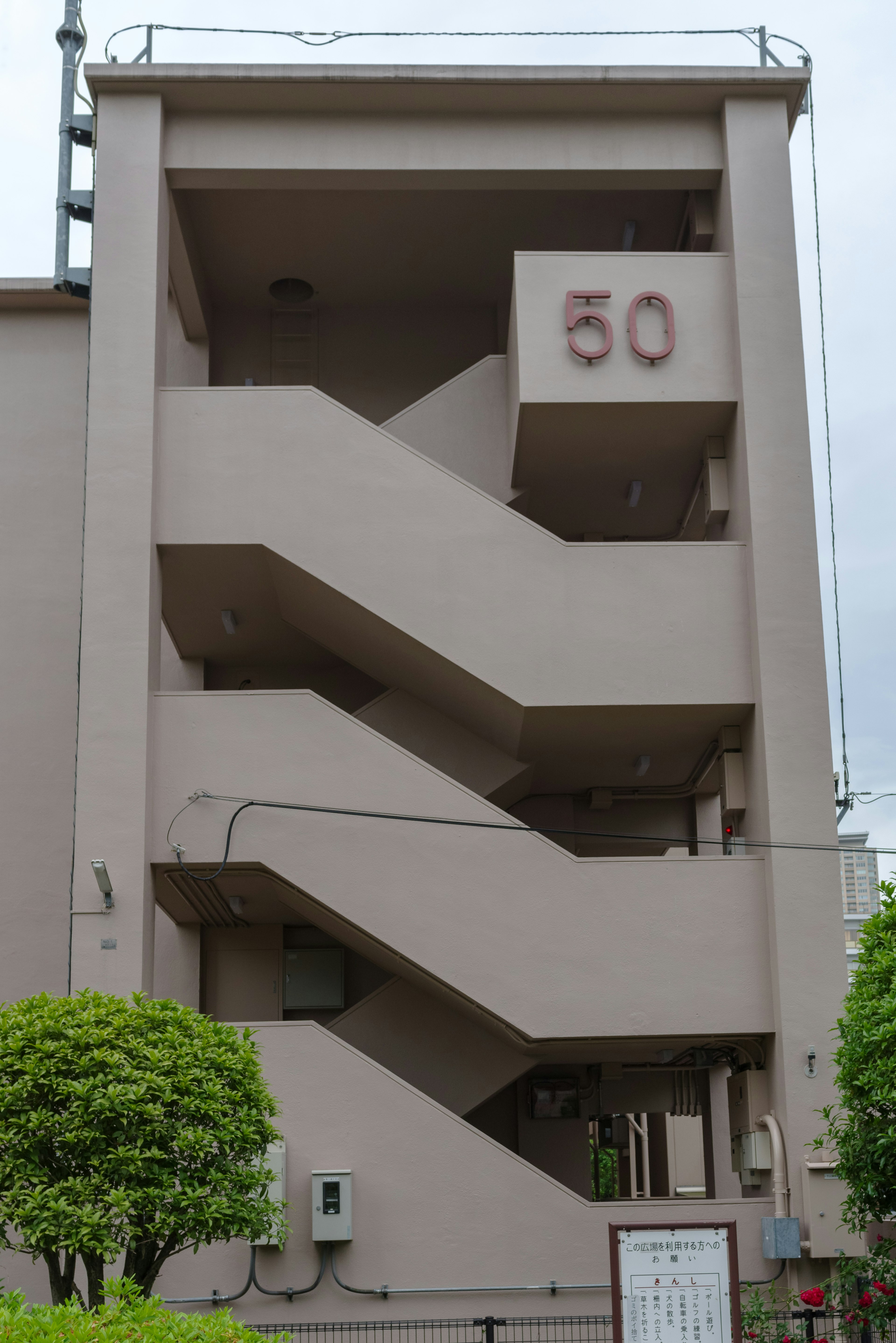 Vista exterior de un edificio con escaleras y el número 50 exhibido