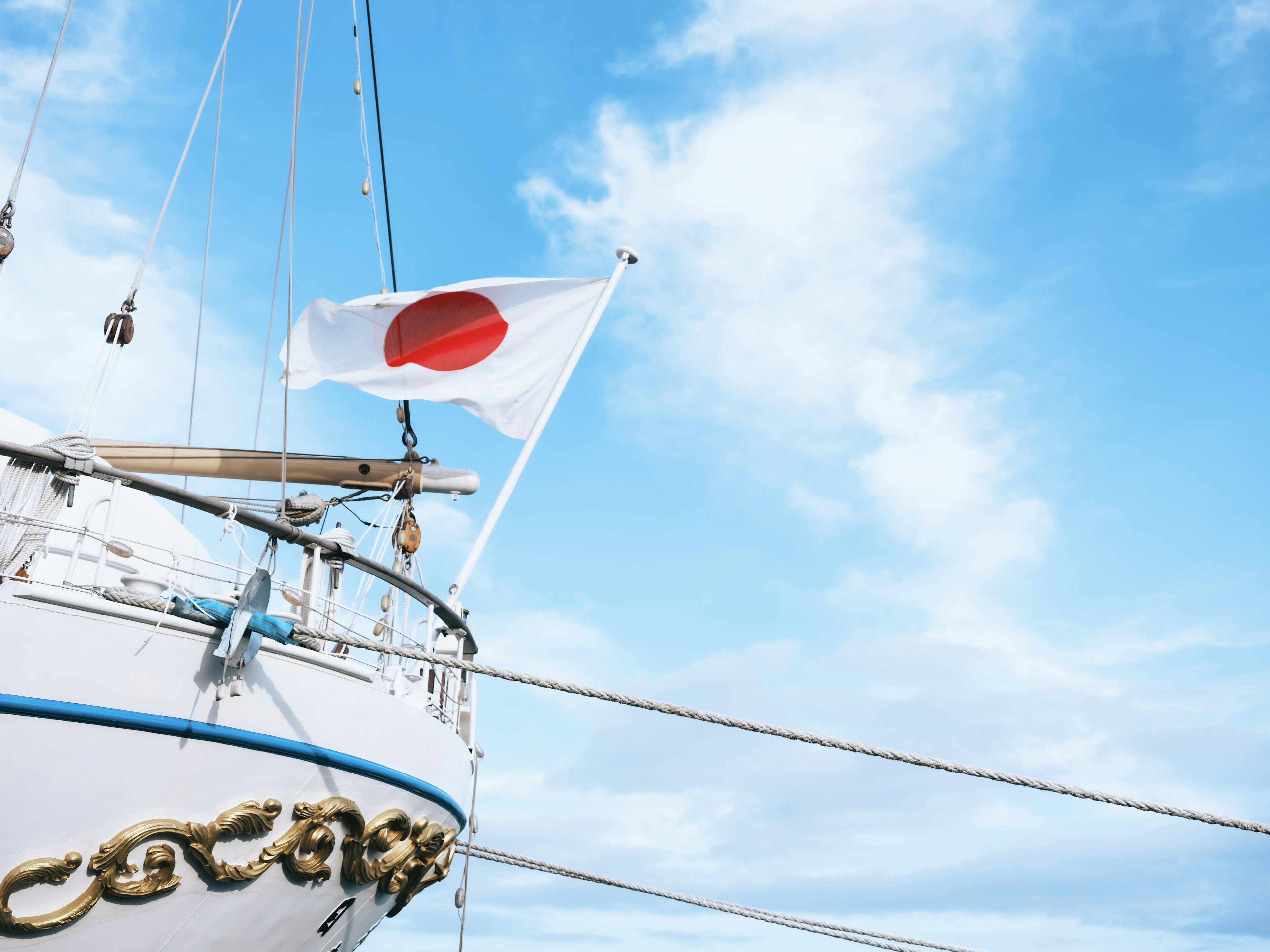 Parte di una nave con la bandiera giapponese sotto un cielo blu