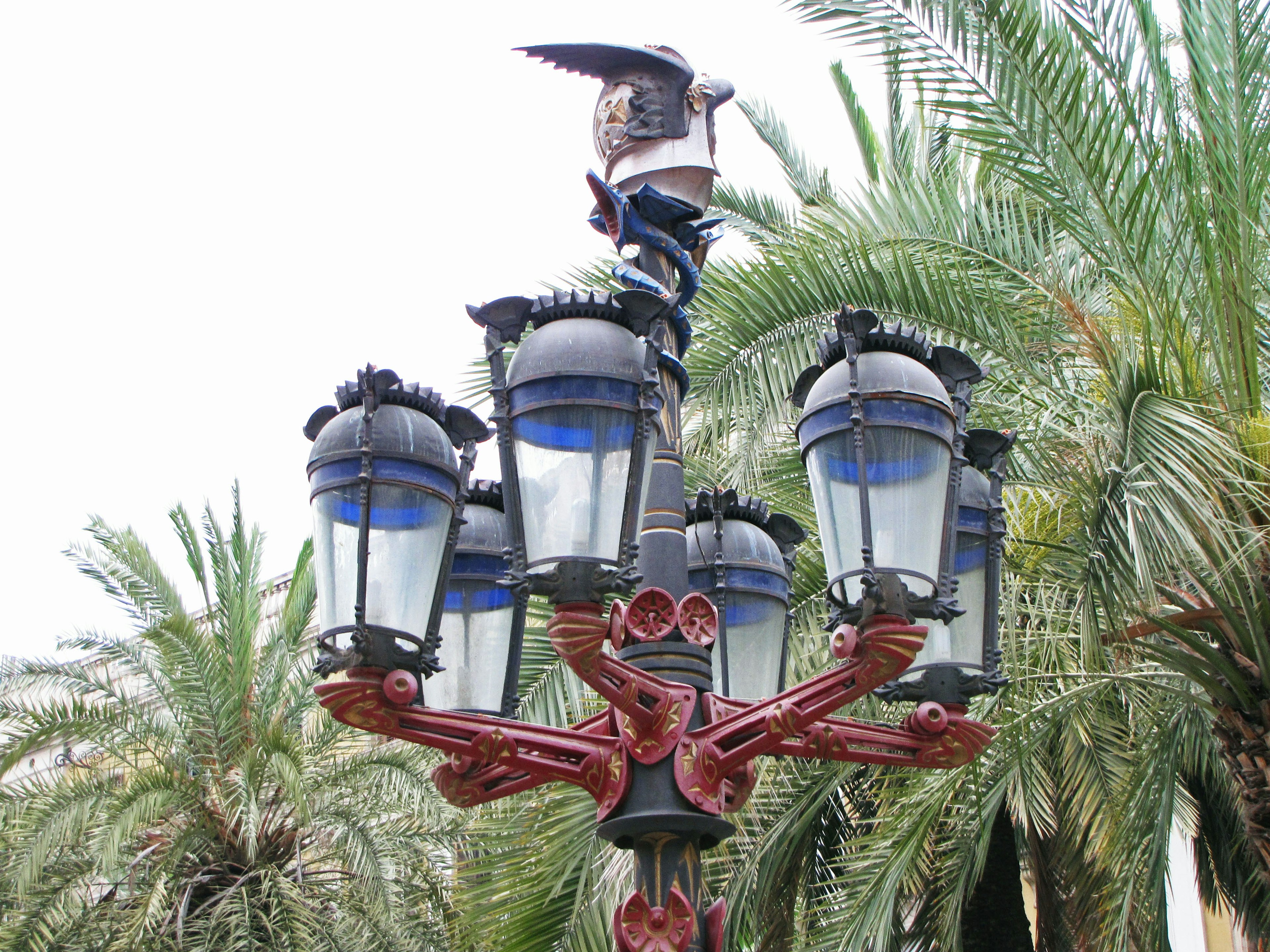 Decorative street lamp with palm trees in the background