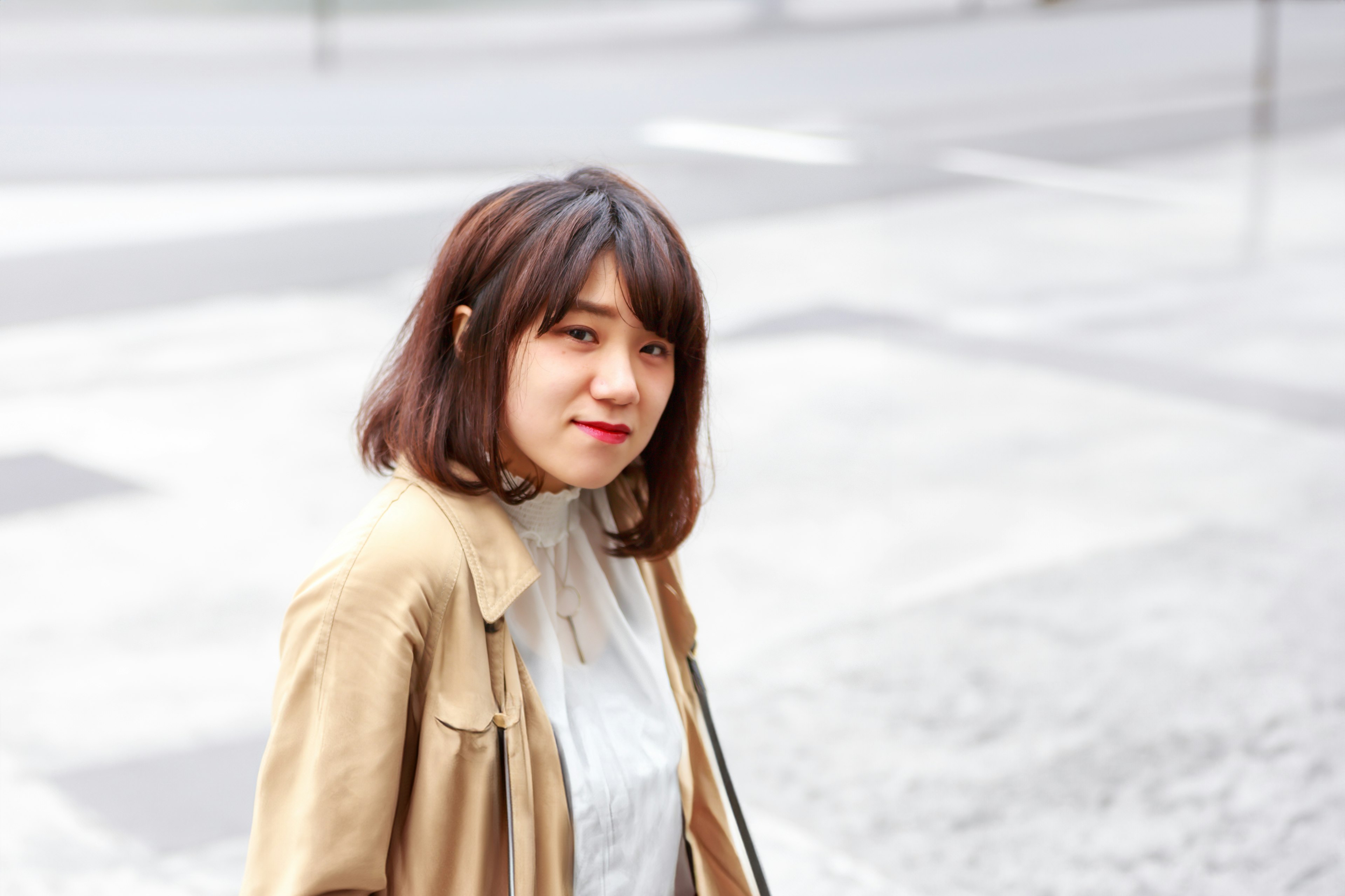 Une femme aux cheveux bruns souriant dans un cadre urbain