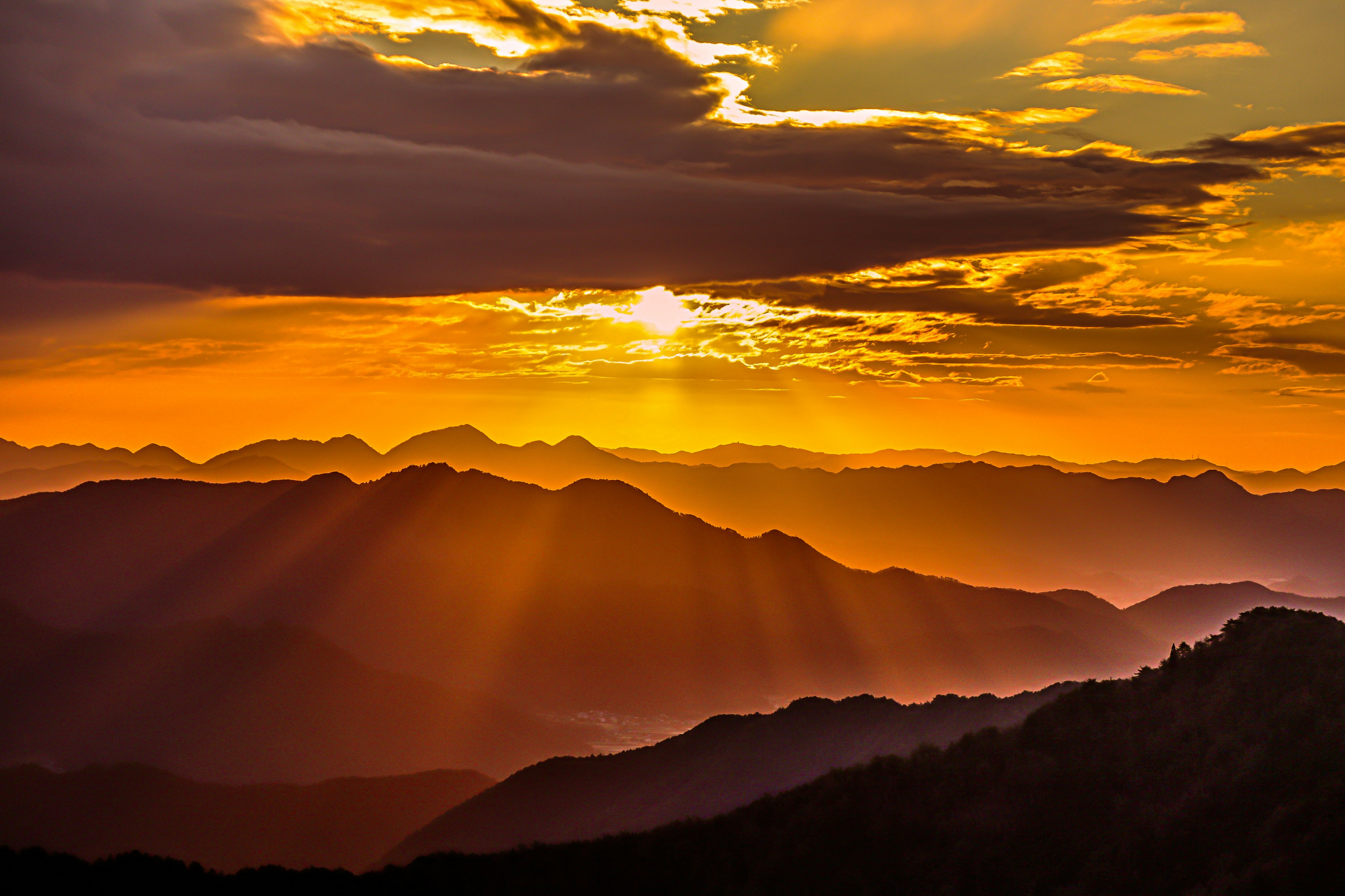 Montagnes en silhouette contre un ciel de coucher de soleil orange vif