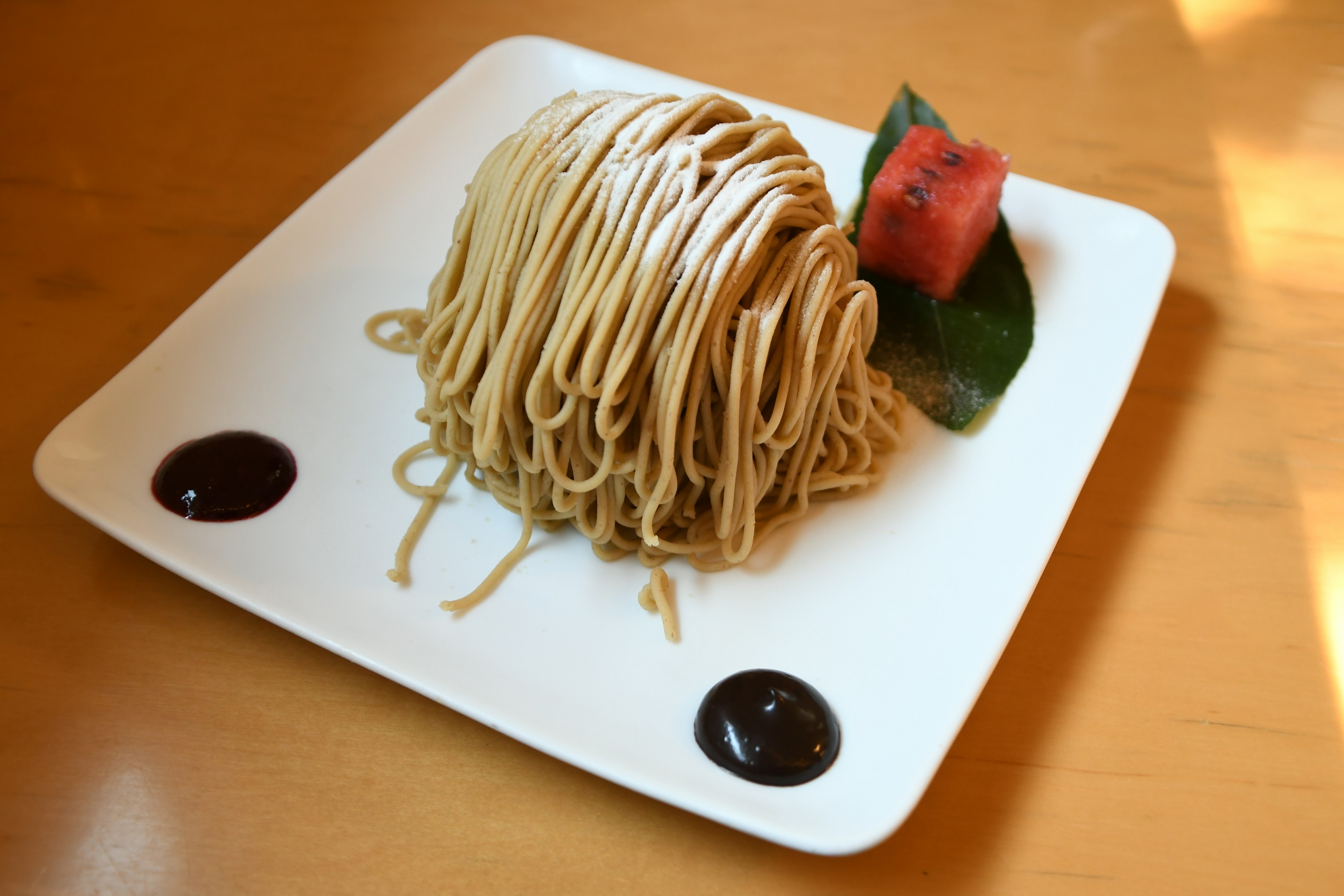 Un mucchio di spaghetti sottili con una fetta di anguria su un piatto