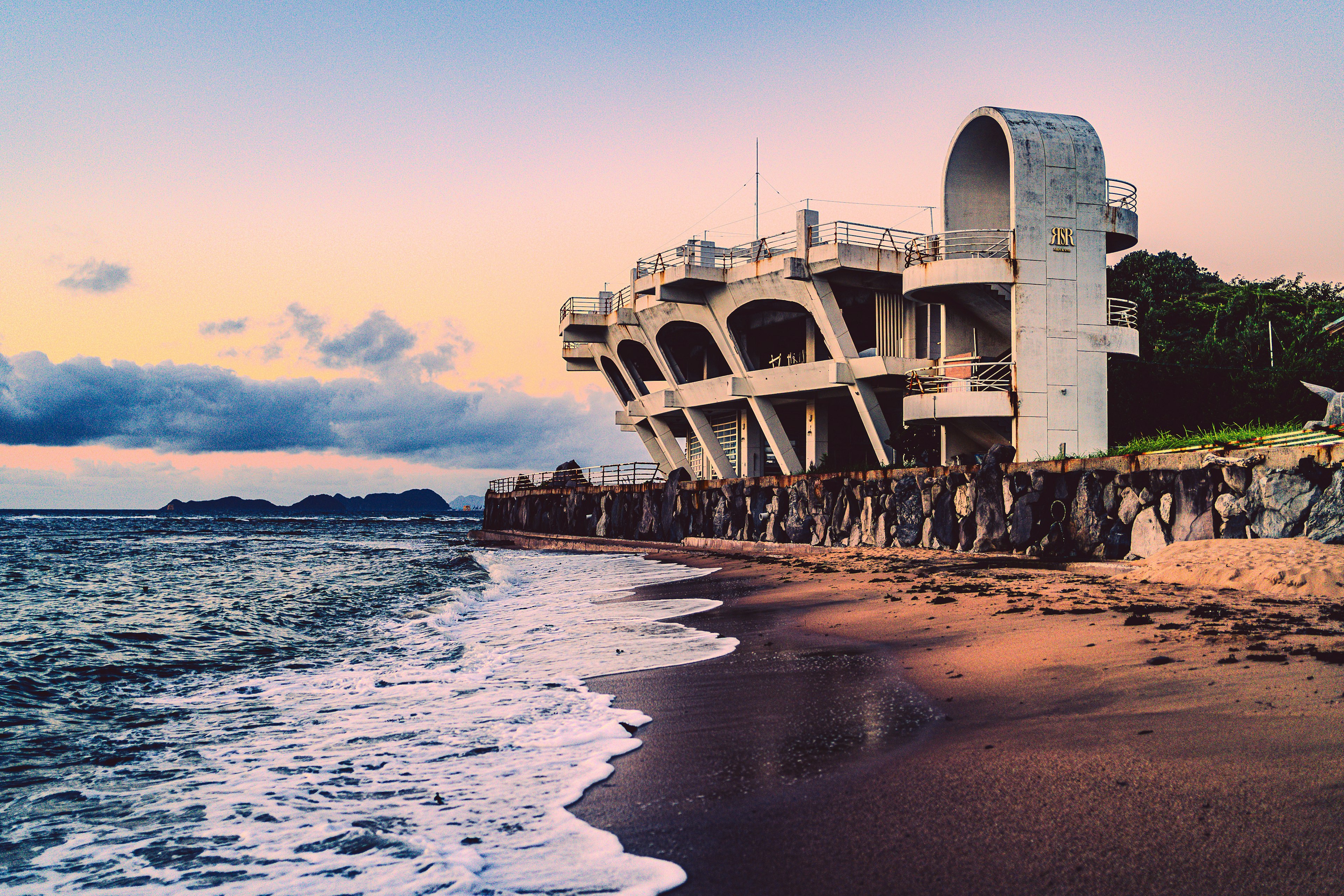 Unique architectural structure on the coast with waves