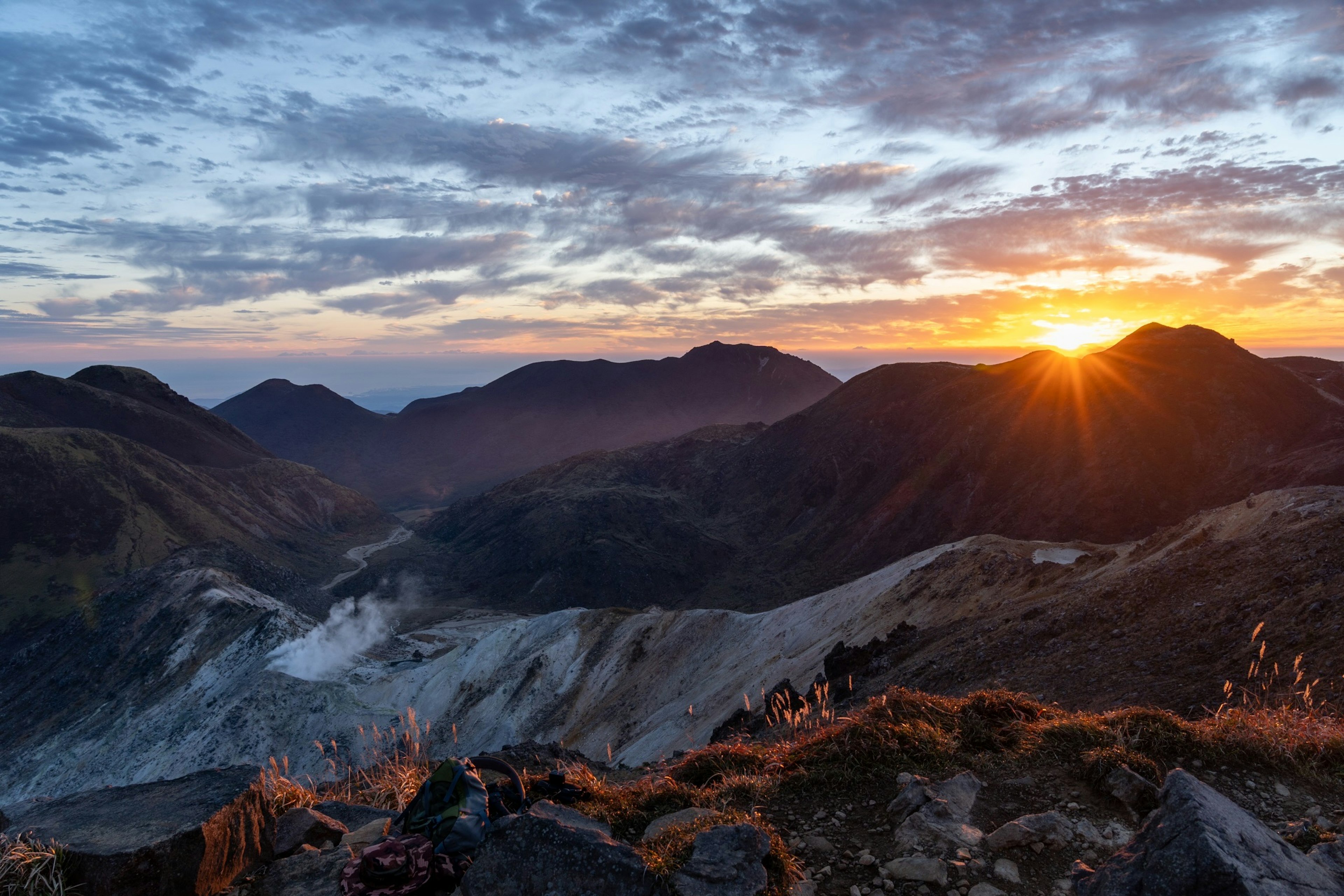 Sunrise over mountains with dramatic clouds and valley view