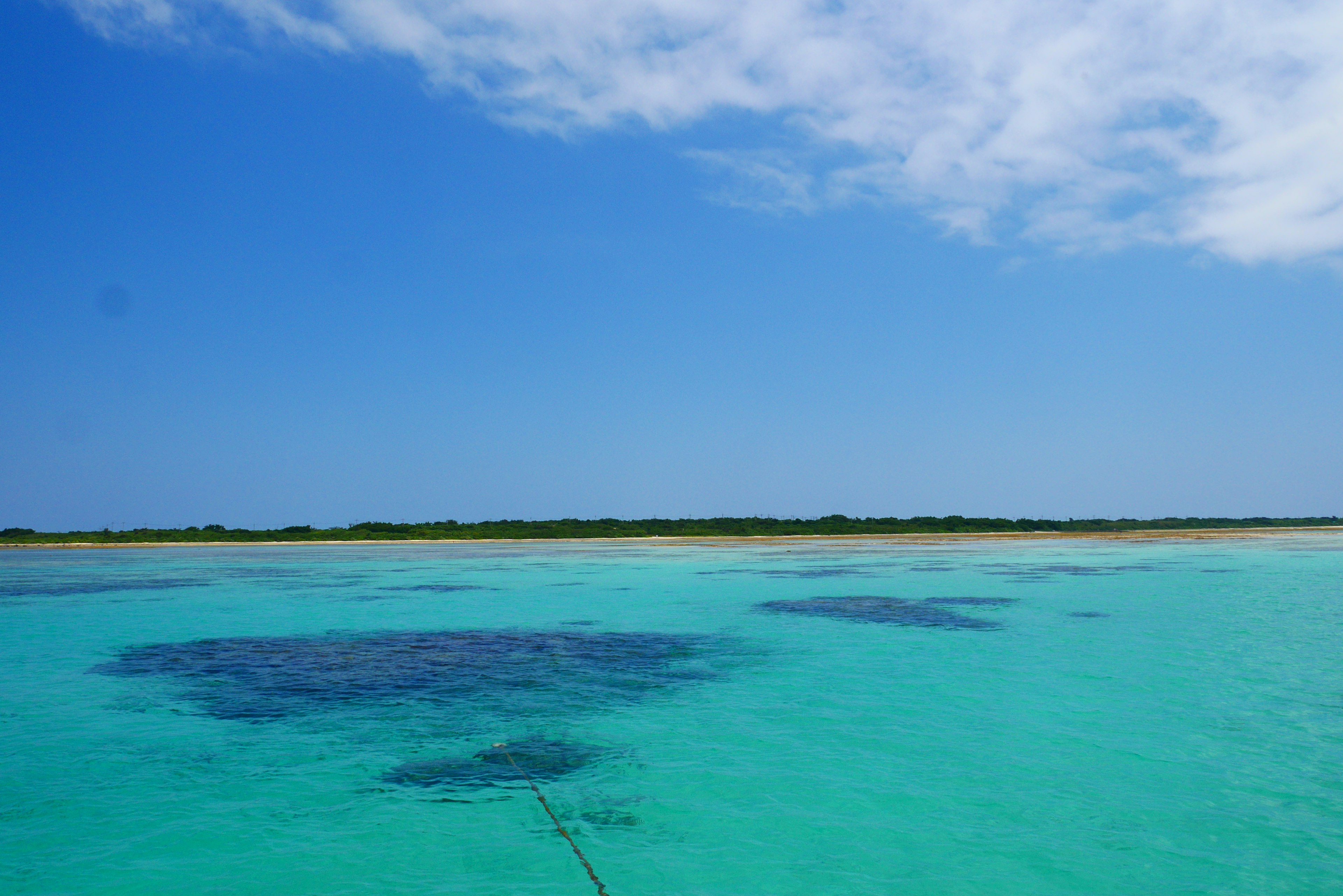 Vista del océano azul y el cielo con islas verdes a lo lejos