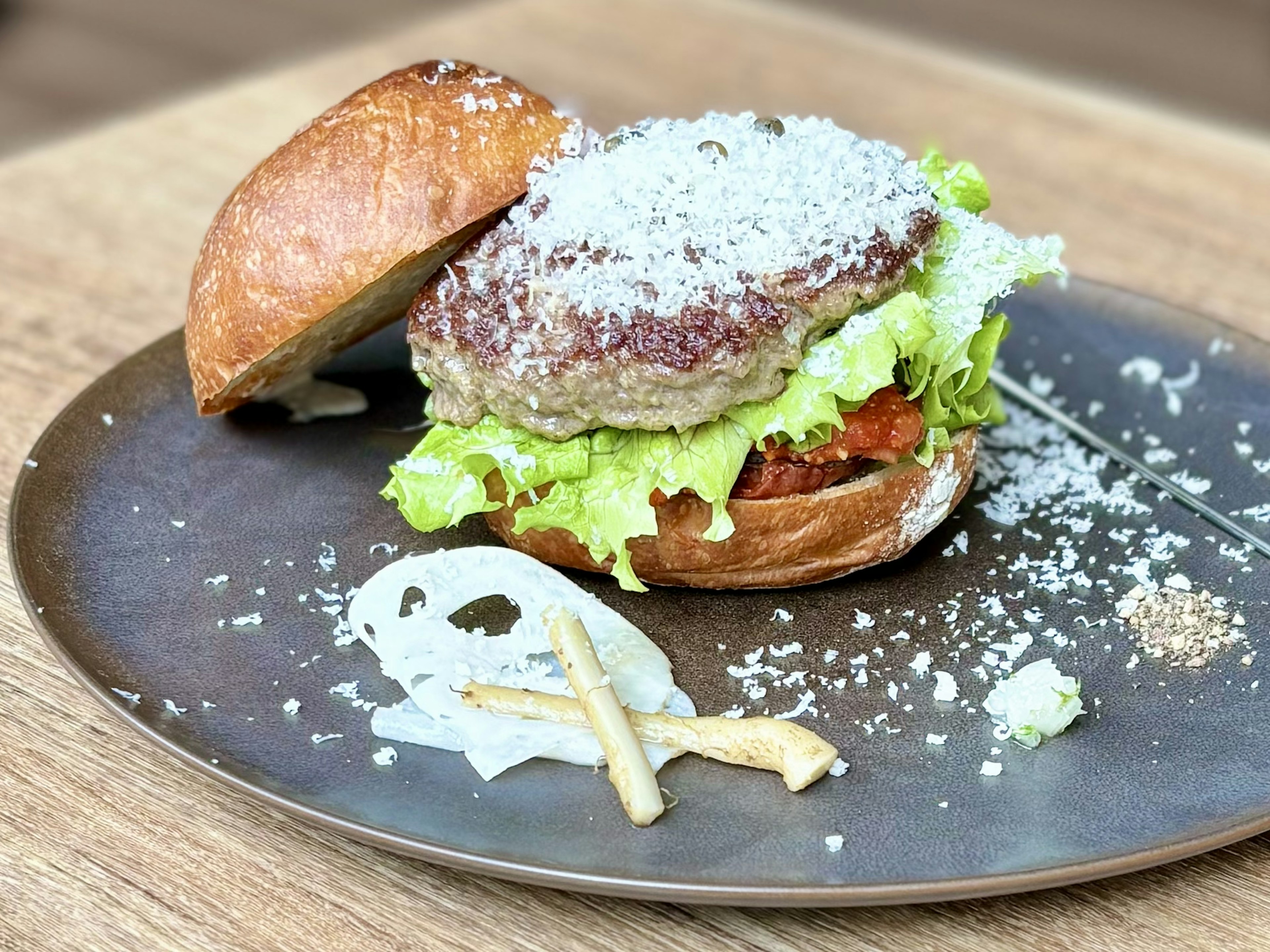 Ein frisch zubereitetes Burgerbrötchen mit Salat und Fleischpatty