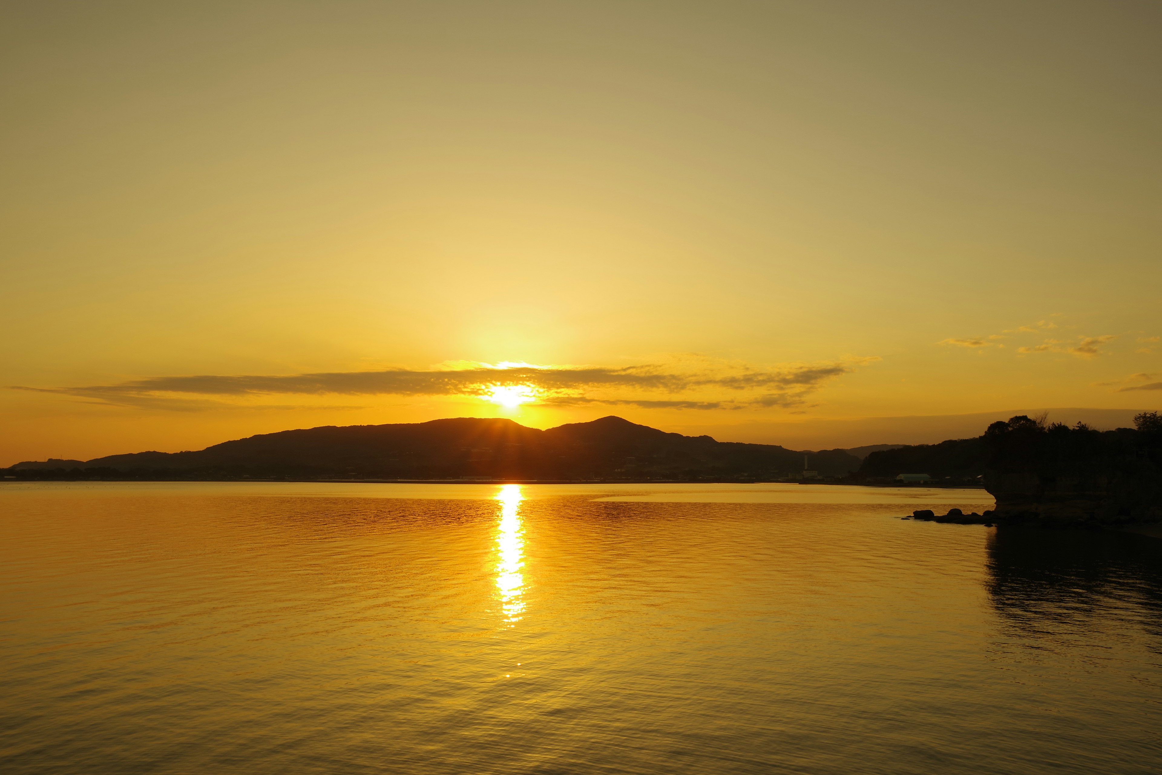 Bellissimo tramonto su un lago calmo con montagne sullo sfondo