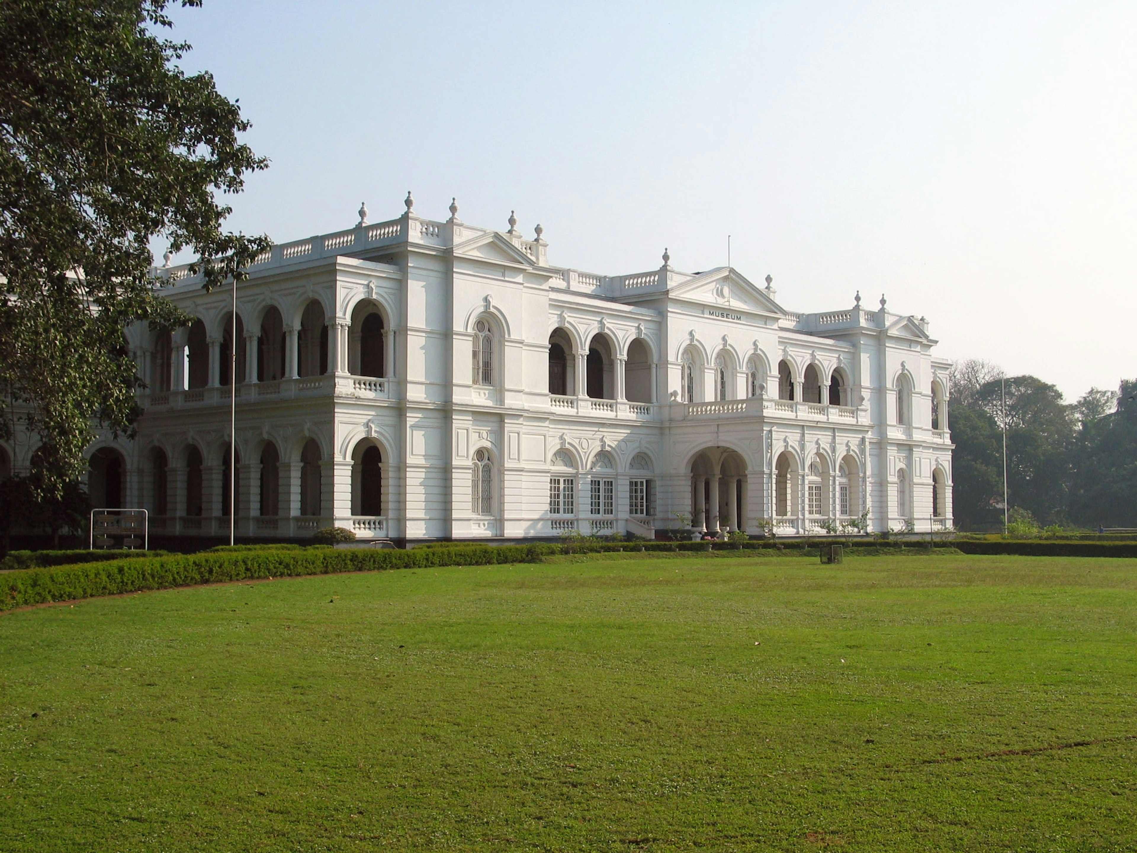 A white building surrounded by lush green grass