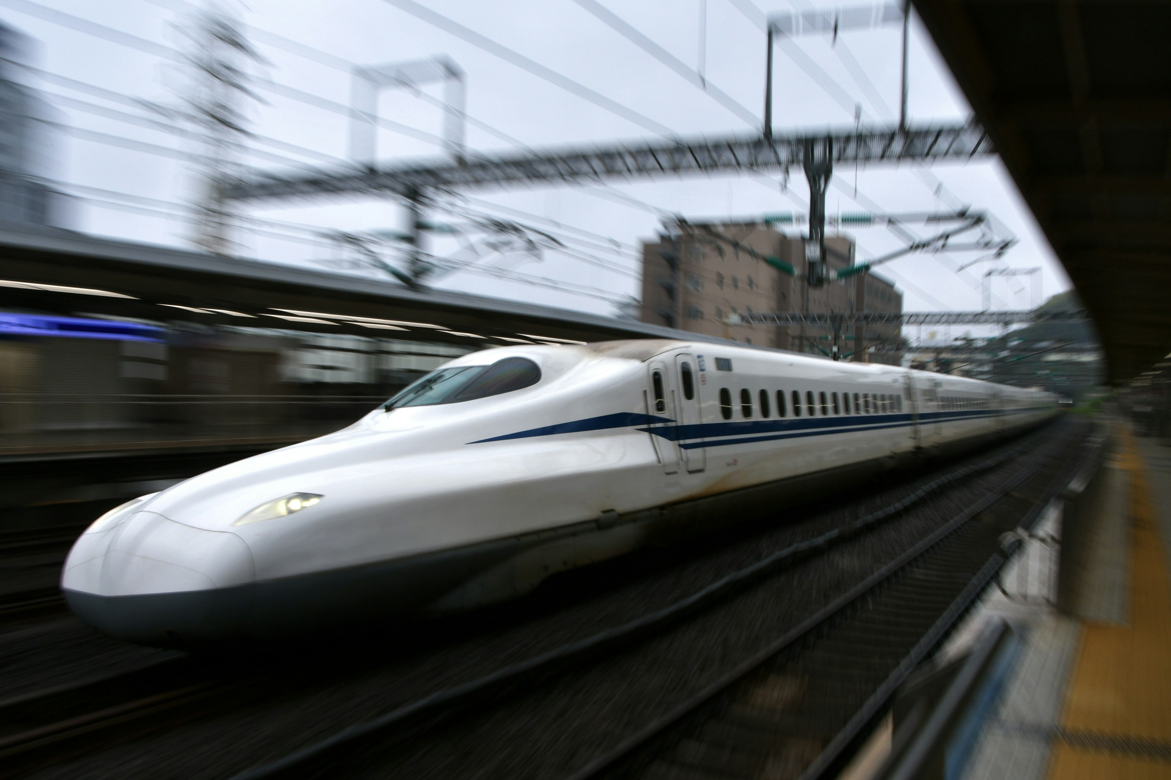 Shinkansen speeding past a station