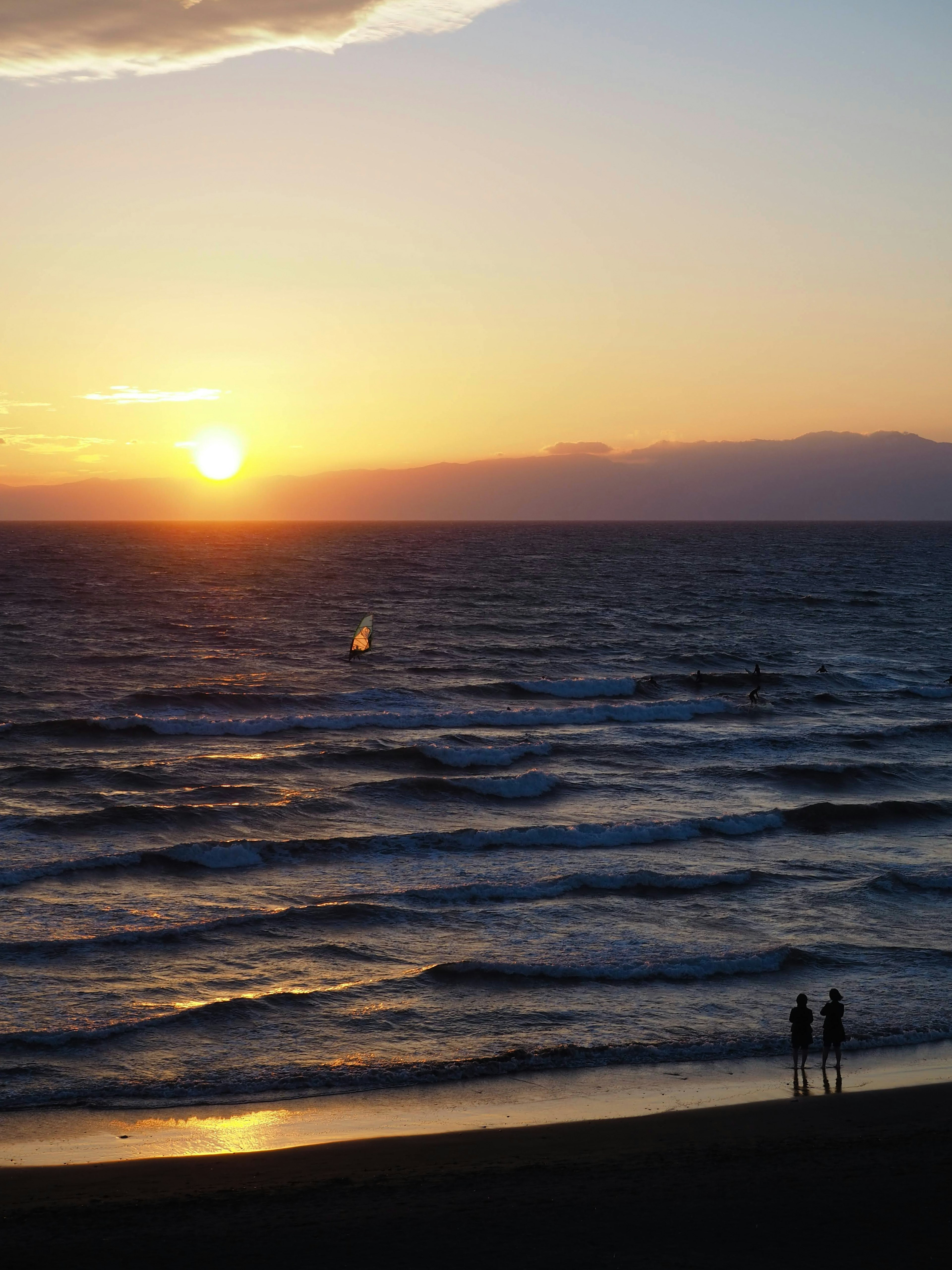 Bellissimo paesaggio di tramonto sull'oceano due silhouette sulla spiaggia