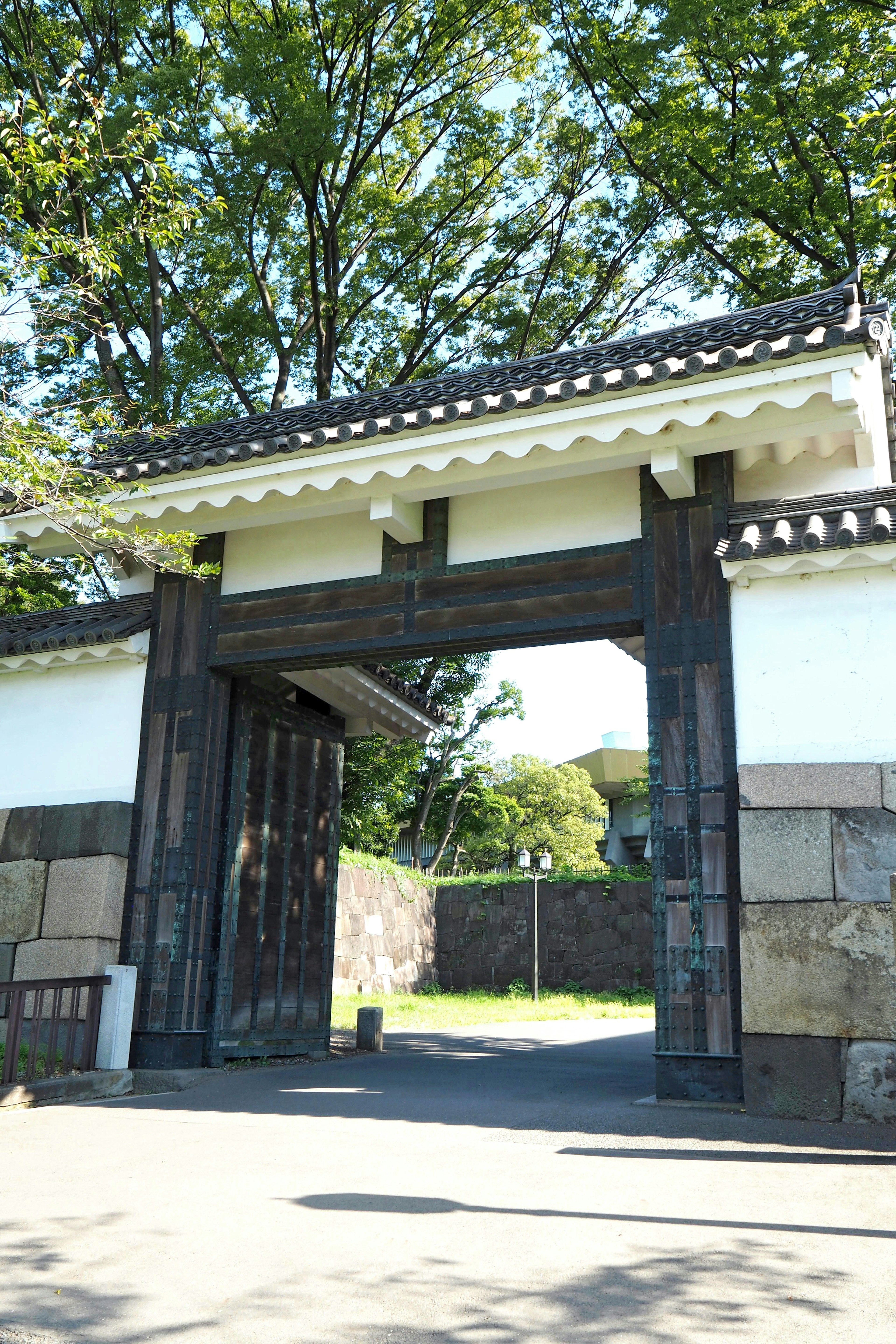 Puerta japonesa tradicional con árboles verdes exuberantes al fondo