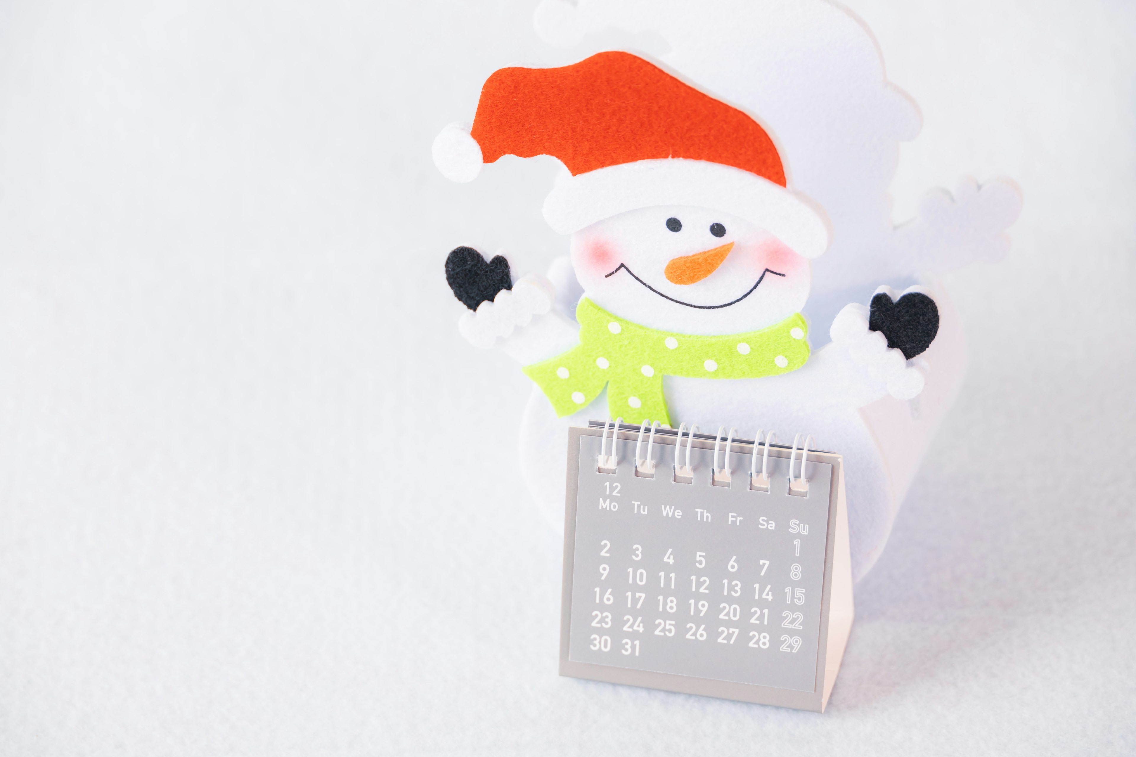 Weihnachtsdekoration mit einem Schneemann, der einen Kalender hält