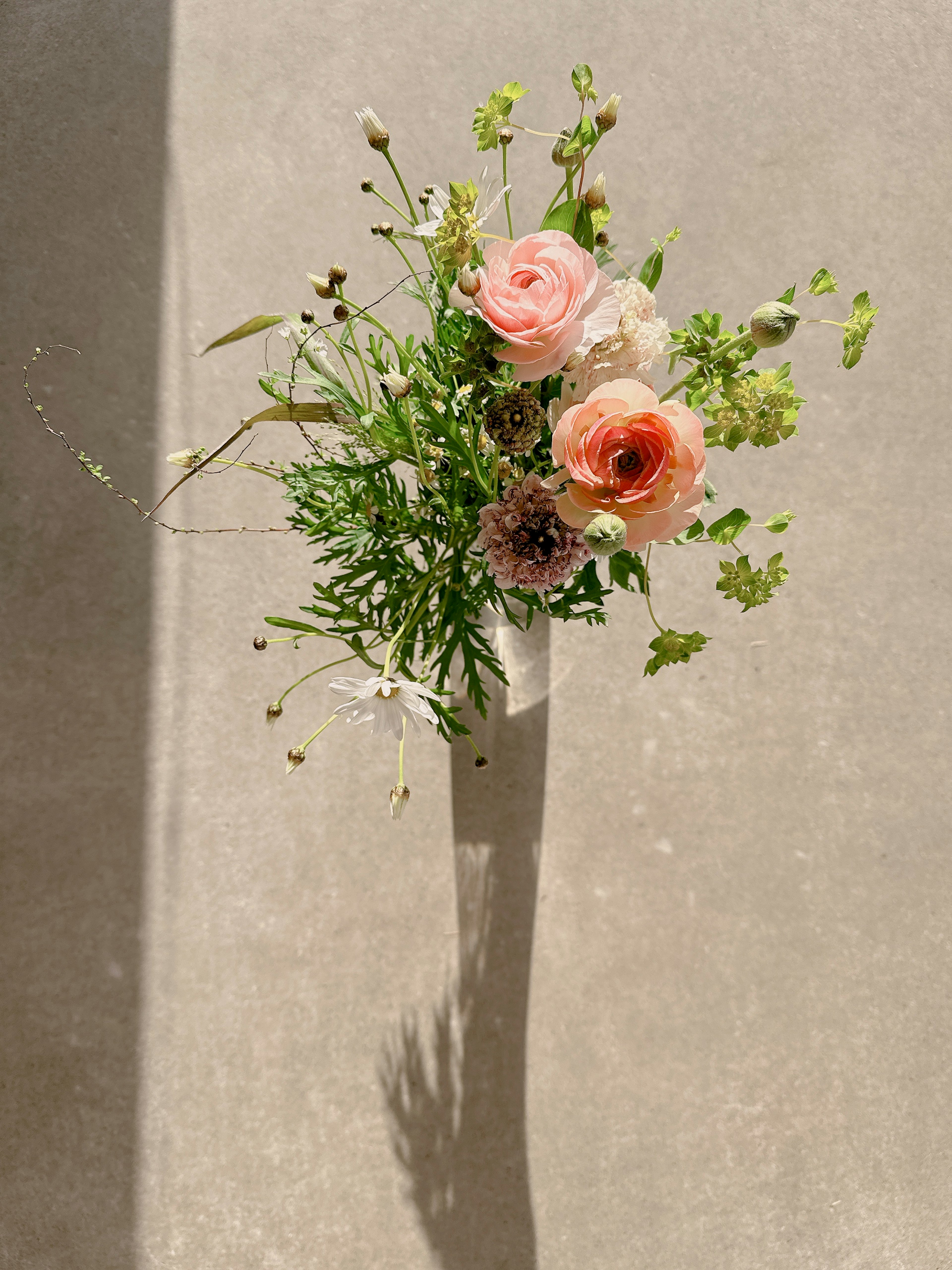 Top view of a vase with pink roses and greenery