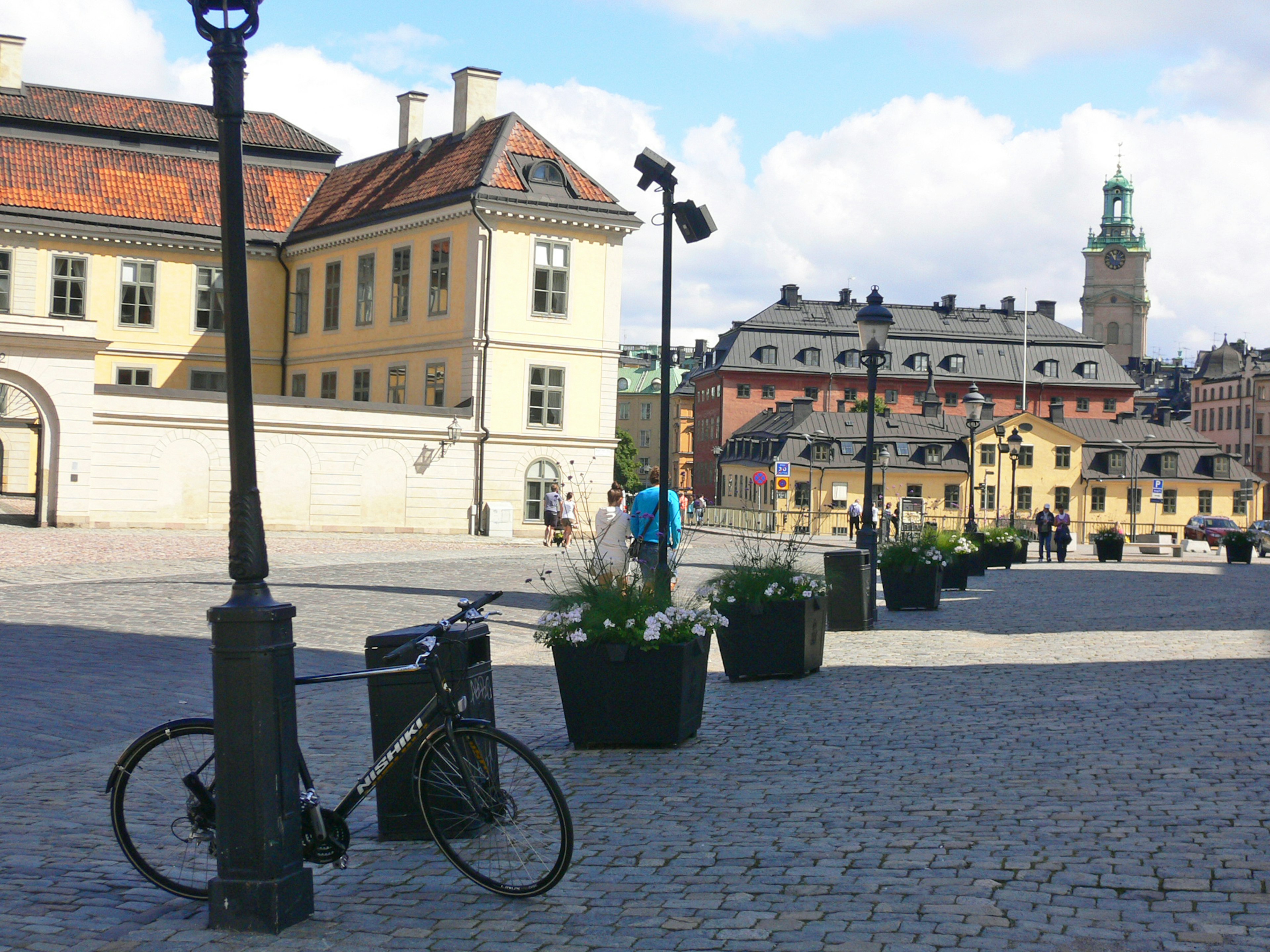 Vélo garé dans une place avec des jardinières à fleurs à Stockholm