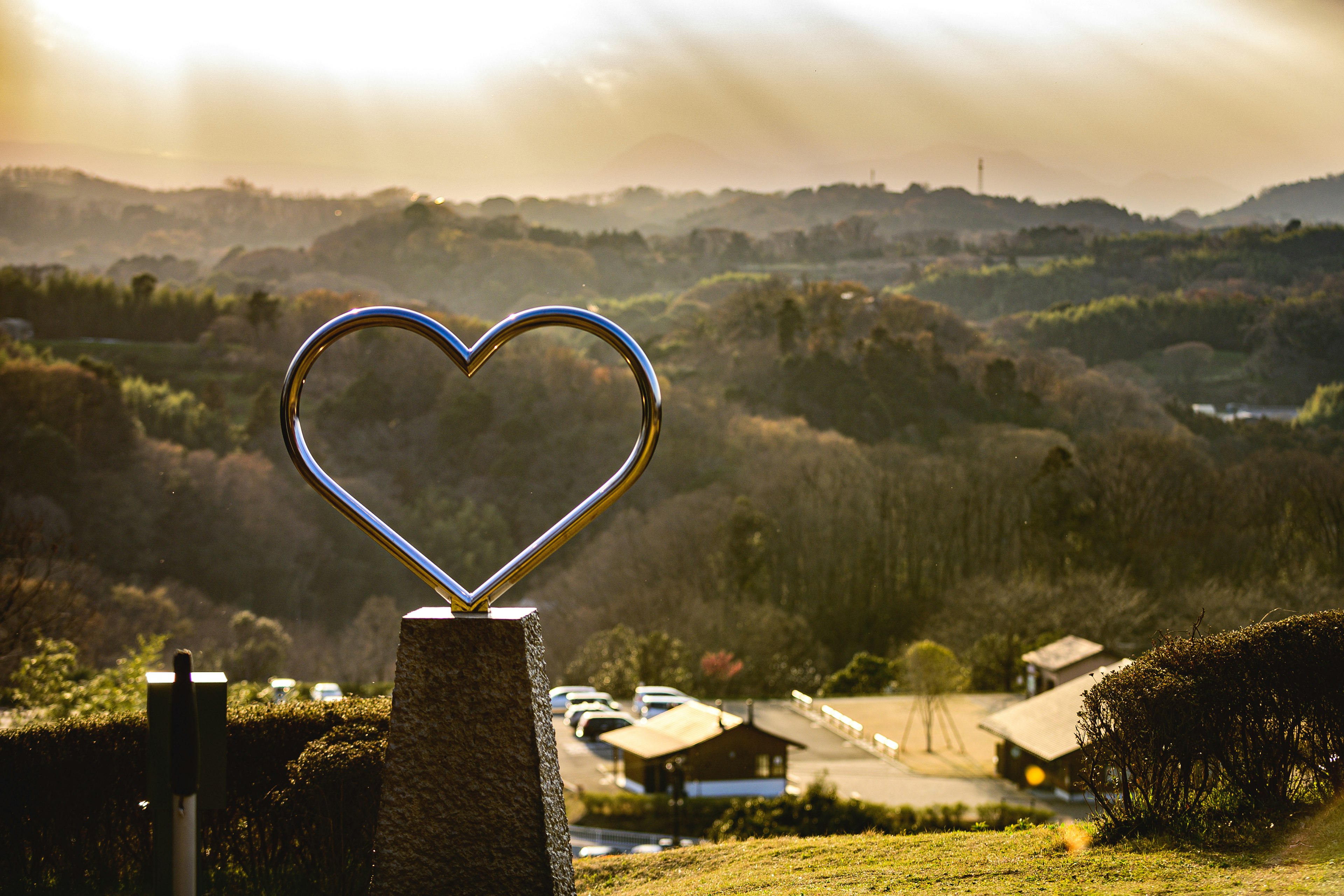 Scenic view featuring a heart-shaped sculpture against a sunset