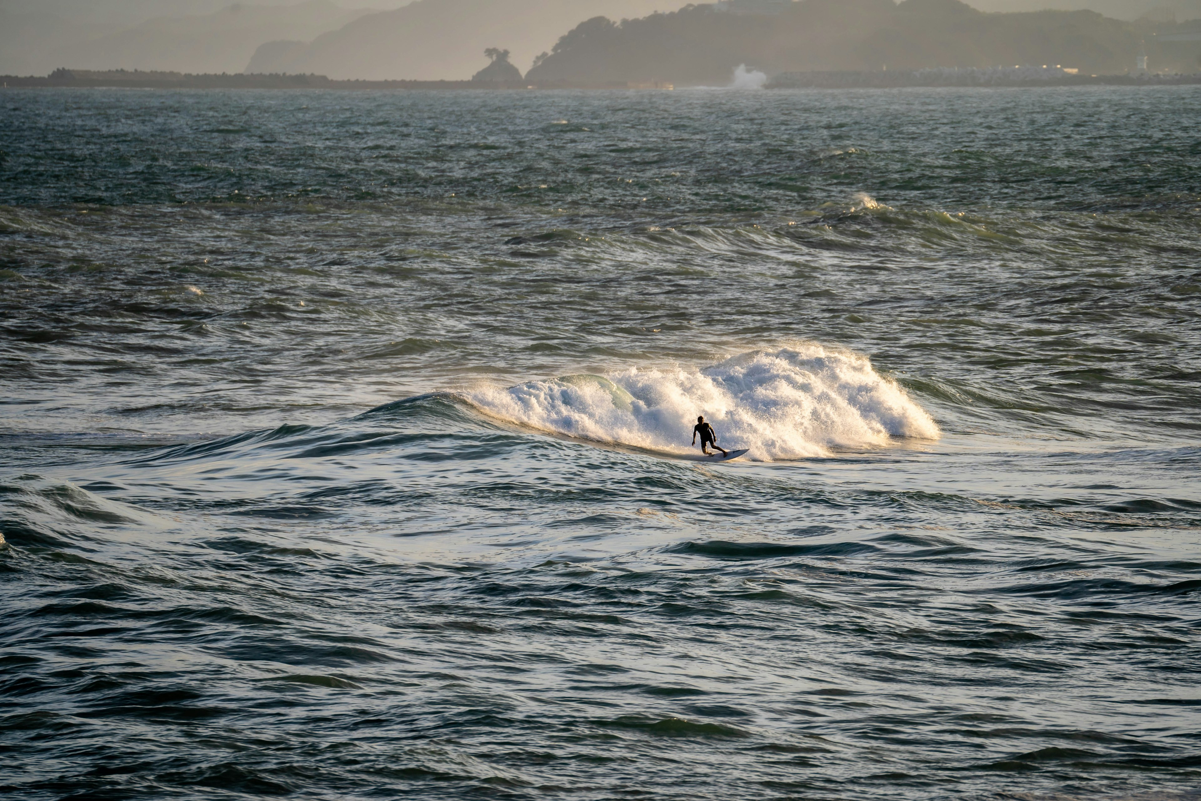 Surfer reitet auf einer Welle mit malerischer Meeresansicht